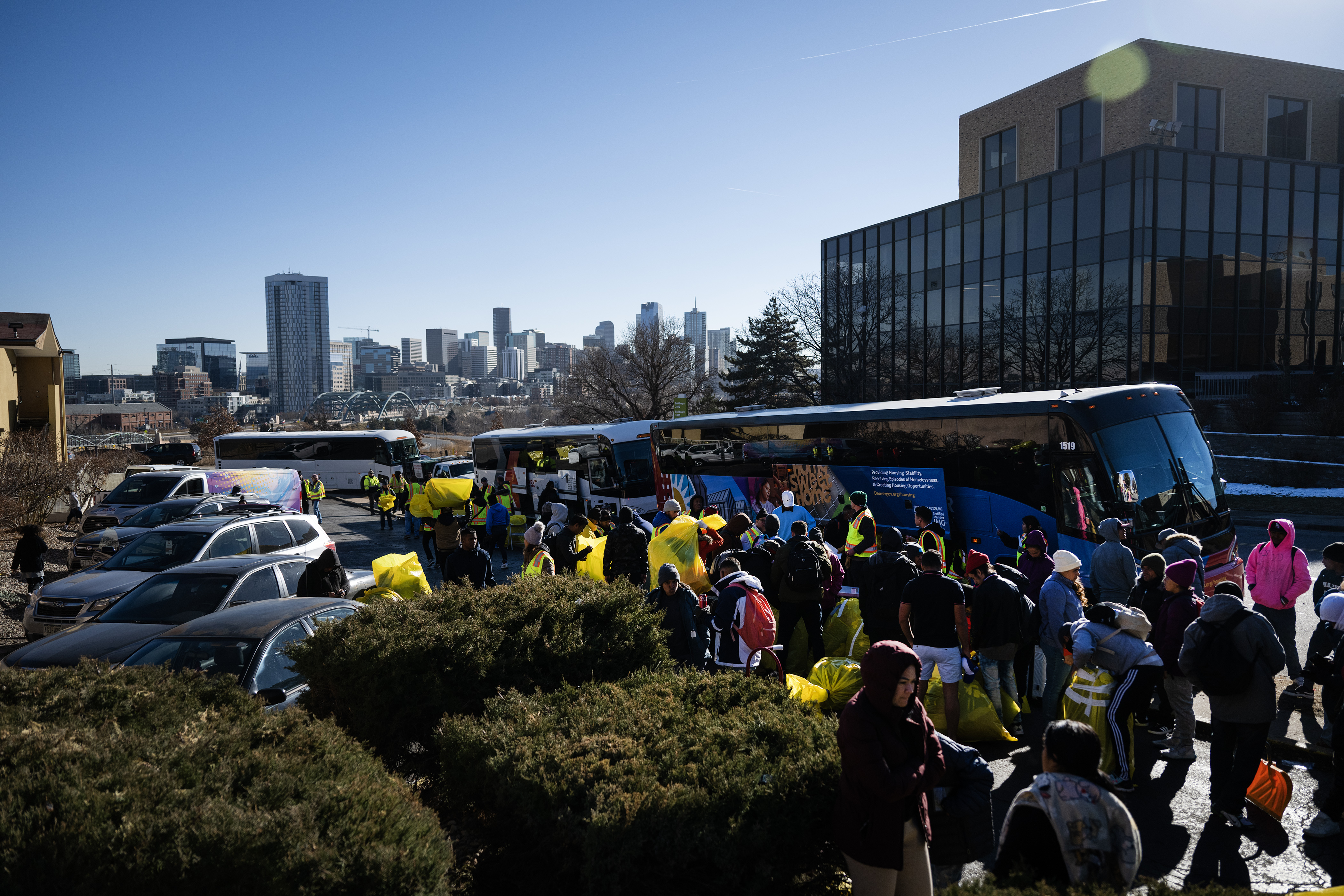 Immigrants stage outside of busses with their belongings in large bags during an encampment sweep at West 27th Avenue, between Zuni and Alcott Streets on Wednesday, Jan. 3, 2024, in Denver, Colo. (Timothy Hurst/Denver Gazette) (TimHursttim.hurst@gazette.comhttps://secure.gravatar.com/avatar/aca82bd62b4ee425c598527cd6faa1b1?d=mm&r=g)