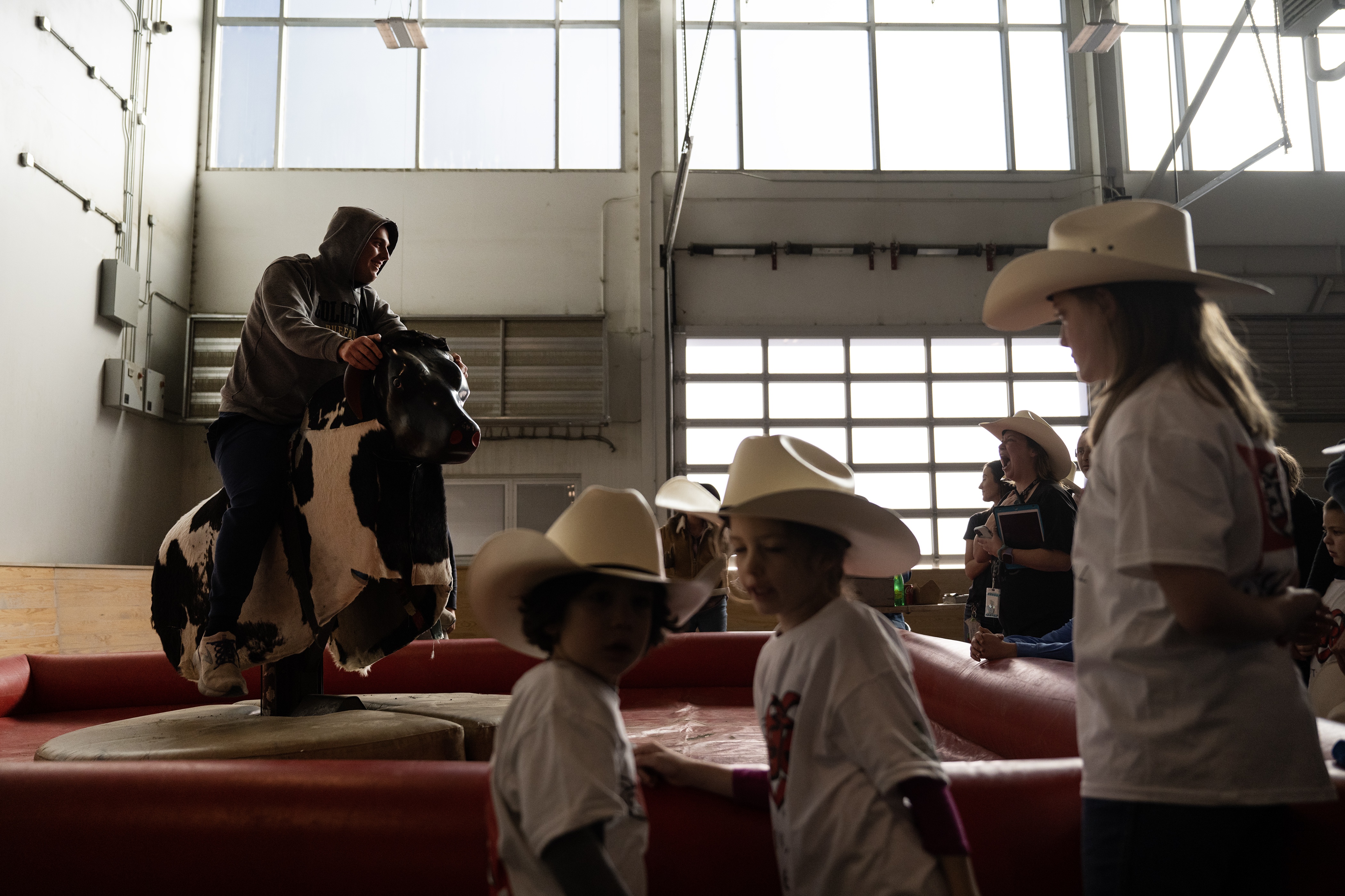 Rodeo participants look on as Jack Griffith rides the mechanical bull during the annual PRCA Exceptional Rodeo on Thursday, Jan. 18, 2024, at the Temple Grandin Equine Center at Colorado State University Spur in Denver, Colo. (Timothy Hurst/Denver Gazette) (TimHursttim.hurst@gazette.comhttps://secure.gravatar.com/avatar/aca82bd62b4ee425c598527cd6faa1b1?d=mm&r=g)