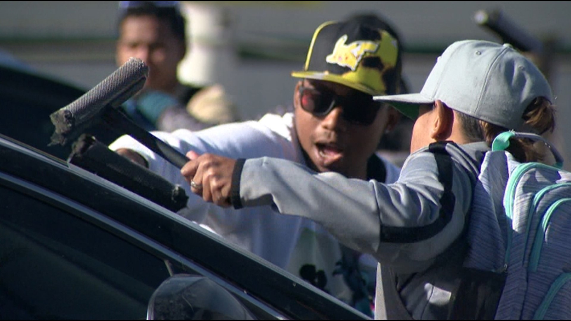 Migrants clean a car windshield in Denver to try to make money in this 9NEWS file image. (9NEWS)