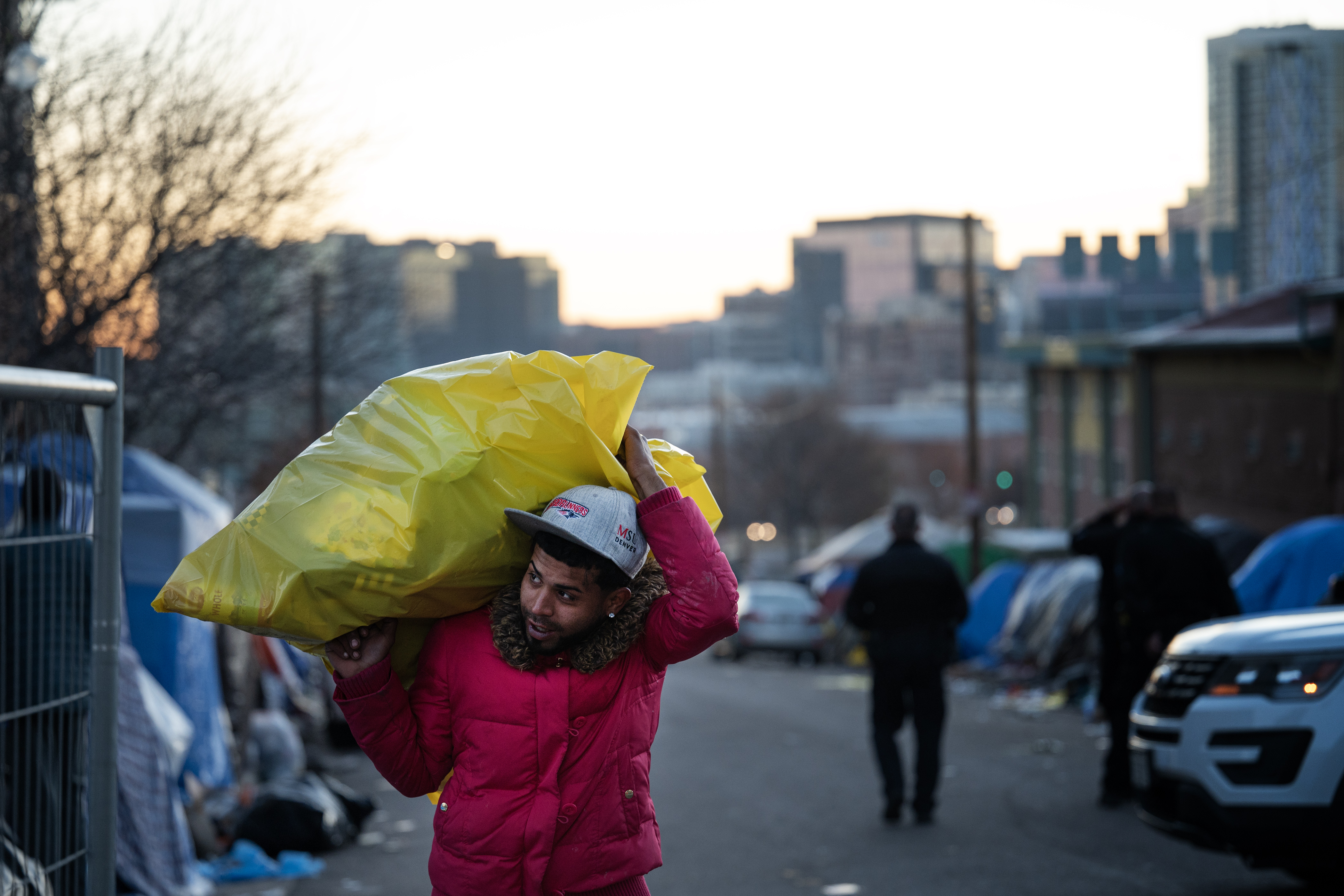 Keyder Quintana, who is from Venezuela, carries a trash bag full of belongings up West 27th Avenue to a car waiting outside the fenced off area of an encampment sweep between Zuni Street and Alcott Street on Wednesday, Jan. 3, 2024, in Denver, Colo. (Timothy Hurst/Denver Gazette) (TimHursttim.hurst@gazette.comhttps://secure.gravatar.com/avatar/aca82bd62b4ee425c598527cd6faa1b1?d=mm&r=g)
