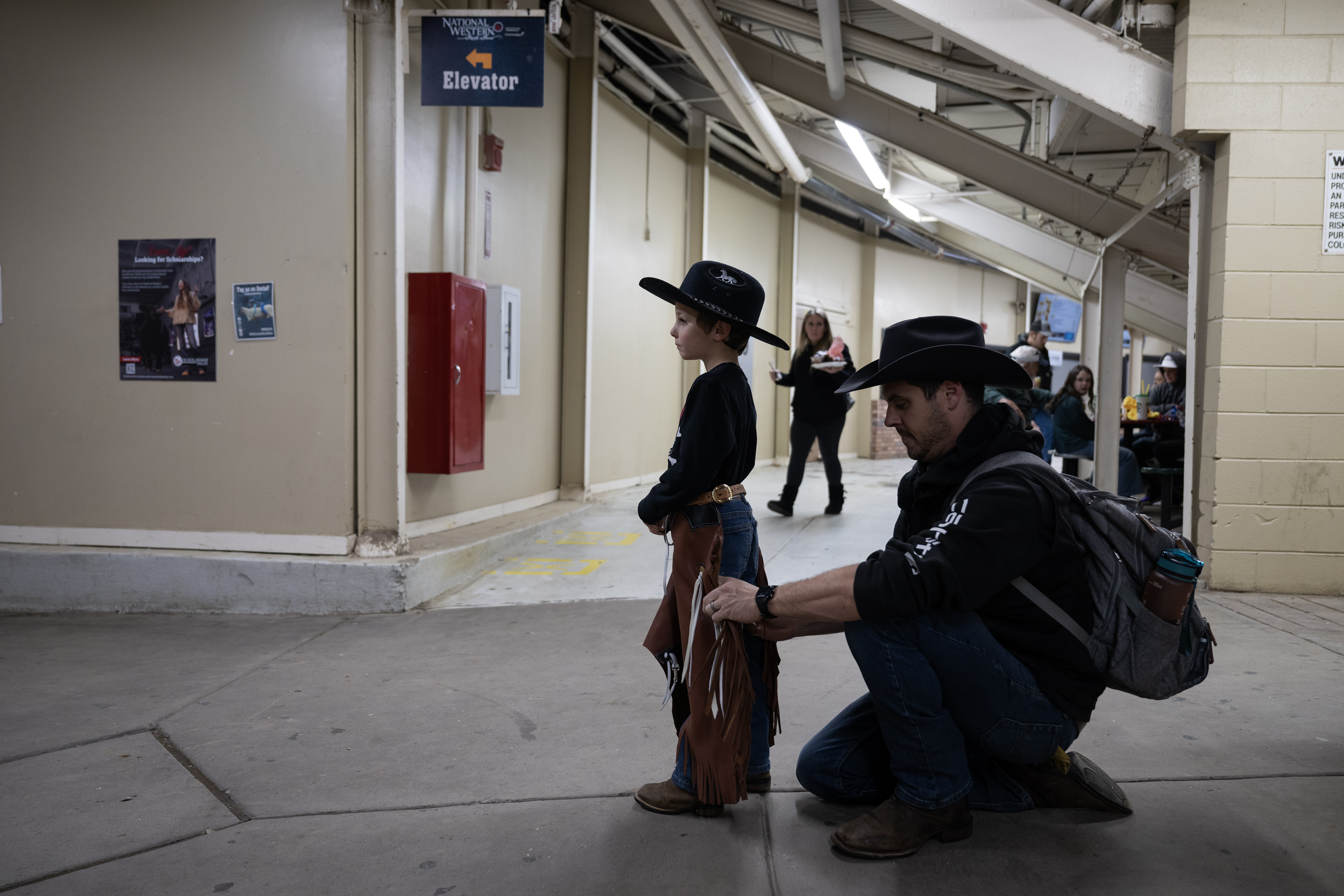Mike Degitis ties up his son Finn’s chaps under the stadium stairs before heading out to compete in the Stadium Arena Mutton Bustin’ event on Monday, Jan. 8, 2024, at the National Western Complex in Denver, Colo. (Timothy Hurst/Denver Gazette) (TimHursttim.hurst@gazette.comhttps://secure.gravatar.com/avatar/aca82bd62b4ee425c598527cd6faa1b1?d=mm&r=g)