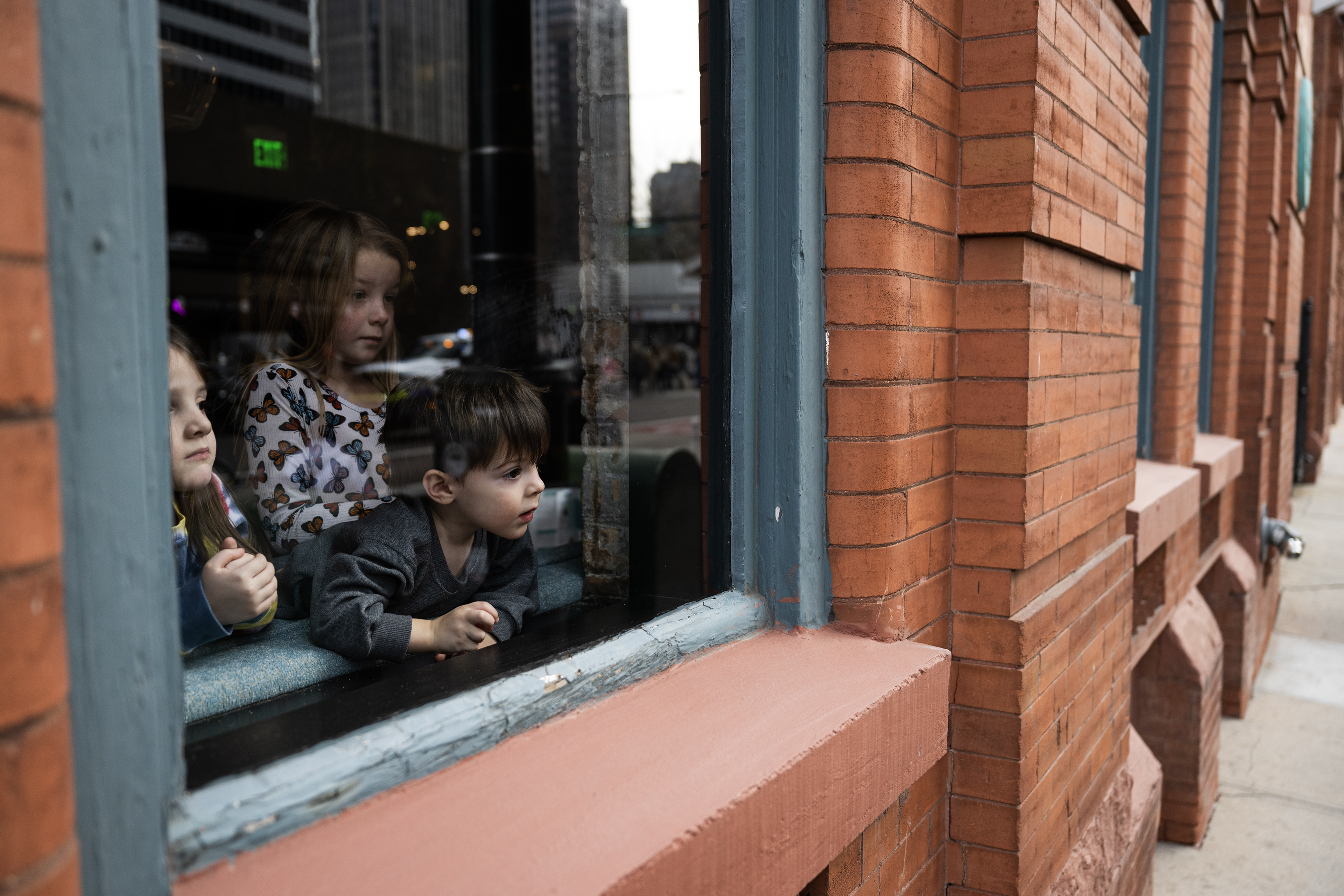 From left, Lou Galati, 4, Michael Galati, 2, and Olivia Lupinacci, 7, watch parade participants make their way down 18th Street while hanging out at Holey Moley Golf Club Denver during The National Western Stock Show Kick-off Parade on Thursday, Jan. 4, 2024, in Denver, Colo. (Timothy Hurst/Denver Gazette) (TimHursttim.hurst@gazette.comhttps://secure.gravatar.com/avatar/aca82bd62b4ee425c598527cd6faa1b1?d=mm&r=g)