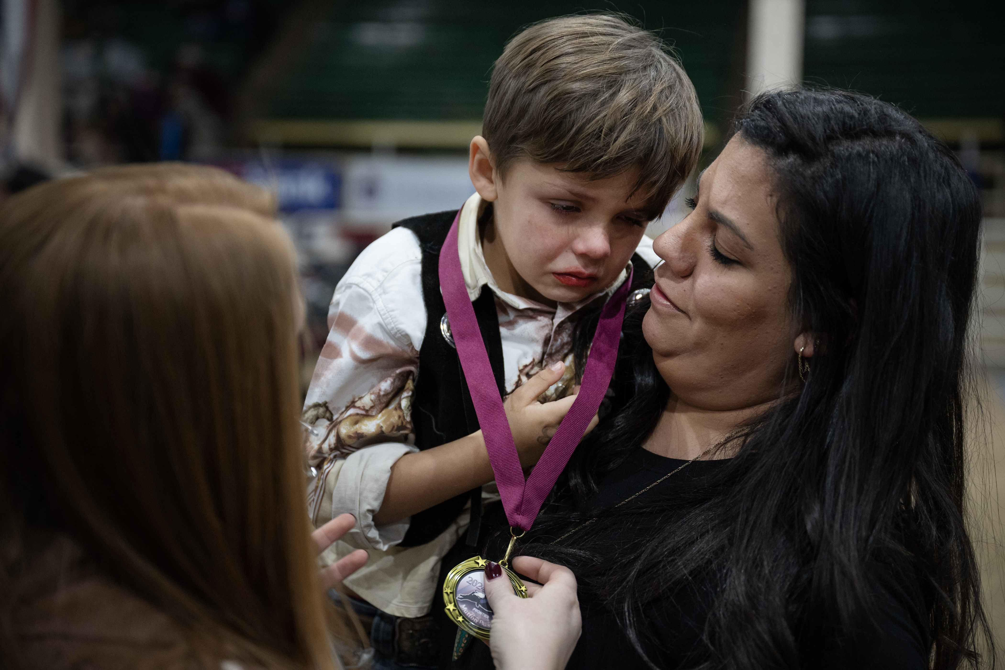 Evita Klava comforts her son Bear Waddell, 5, while Courtney Kroha hangs his medal around his neck after the Stadium Arena Mutton Bustin’ event on Monday, Jan. 8, 2024, at the National Western Complex in Denver, Colo. (Timothy Hurst/Denver Gazette) (TimHursttim.hurst@gazette.comhttps://secure.gravatar.com/avatar/aca82bd62b4ee425c598527cd6faa1b1?d=mm&r=g)