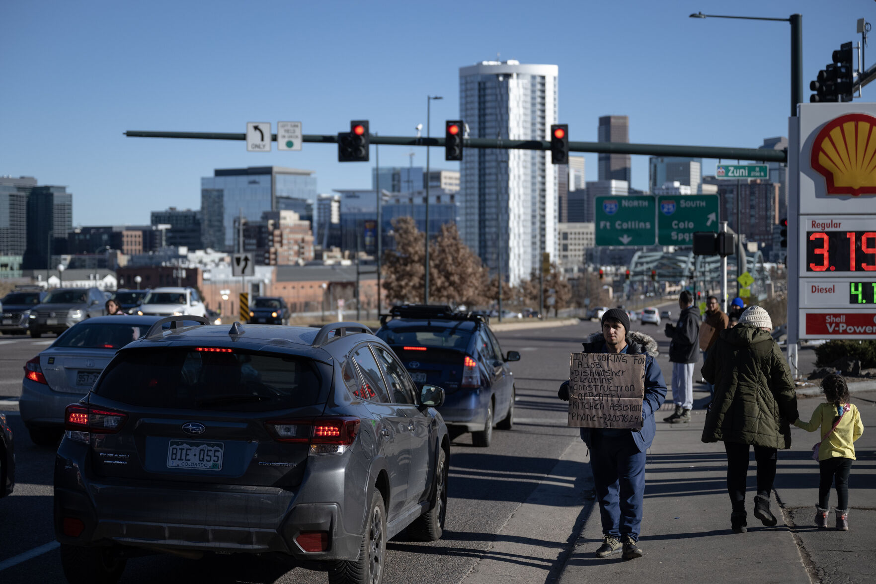 An immigrant holds a sign expressing his desire to work in front of the Shell gas station around the corner from the immigrant encampment at West 27th Avenue and Zuni Street on Friday, Dec. 29, 2023, in Denver, Colo. (Timothy Hurst/Denver Gazette) (TimHursttim.hurst@gazette.comhttps://secure.gravatar.com/avatar/aca82bd62b4ee425c598527cd6faa1b1?d=mm&r=g)