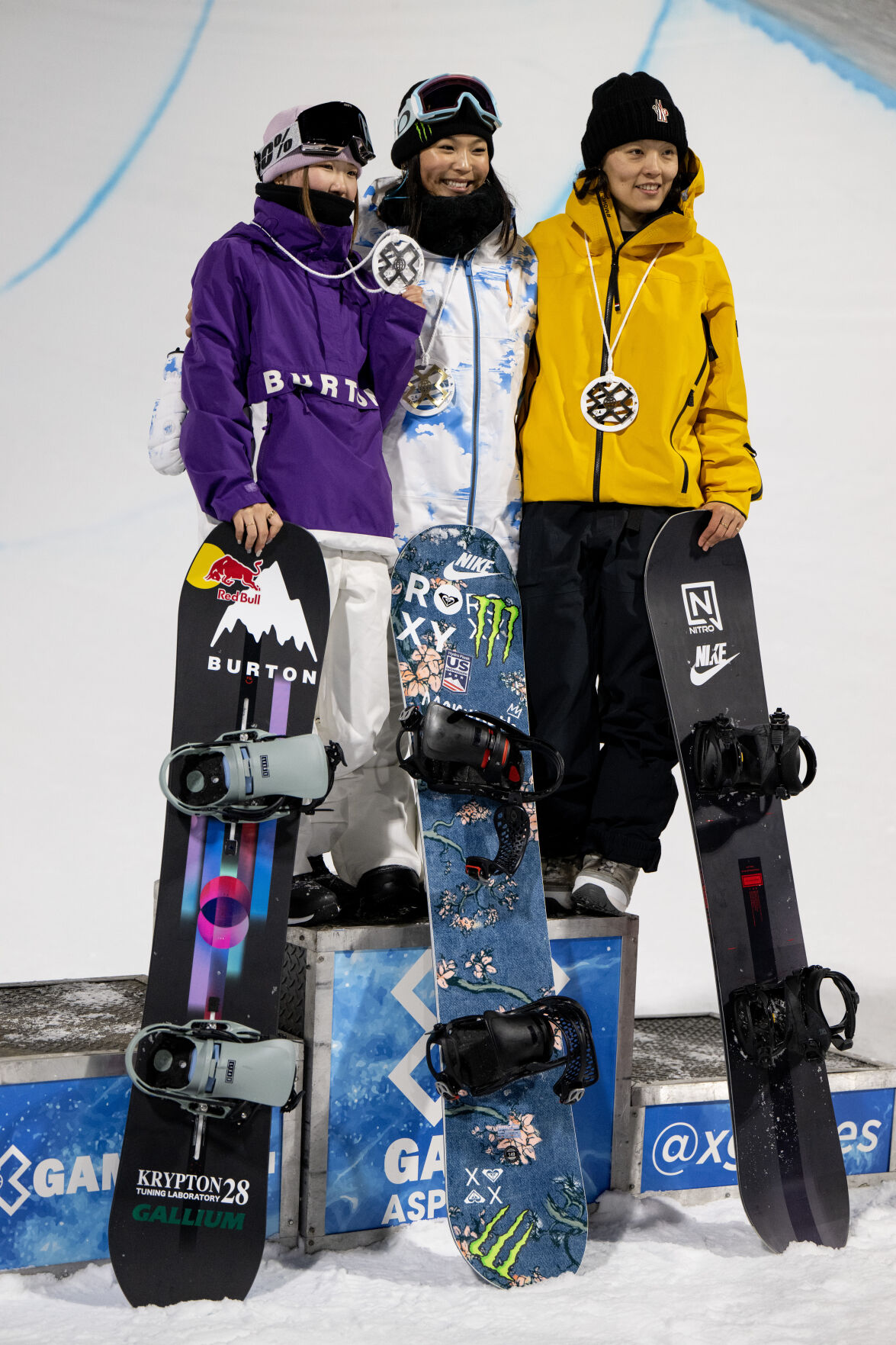 Monster Energy Women's Snowboard SuperPipe gold medalist Chloe Kim, center, invites silver medalist Mitsuki Ono, left, and bronze medalist Xuetong Cai, right, onto the top of the podium for a group picture on day 1 of the X Games Aspen 2024 on January 26, 2024 in Aspen, Colo. (Parker Seibold, The Gazette) (Parker Seibold)