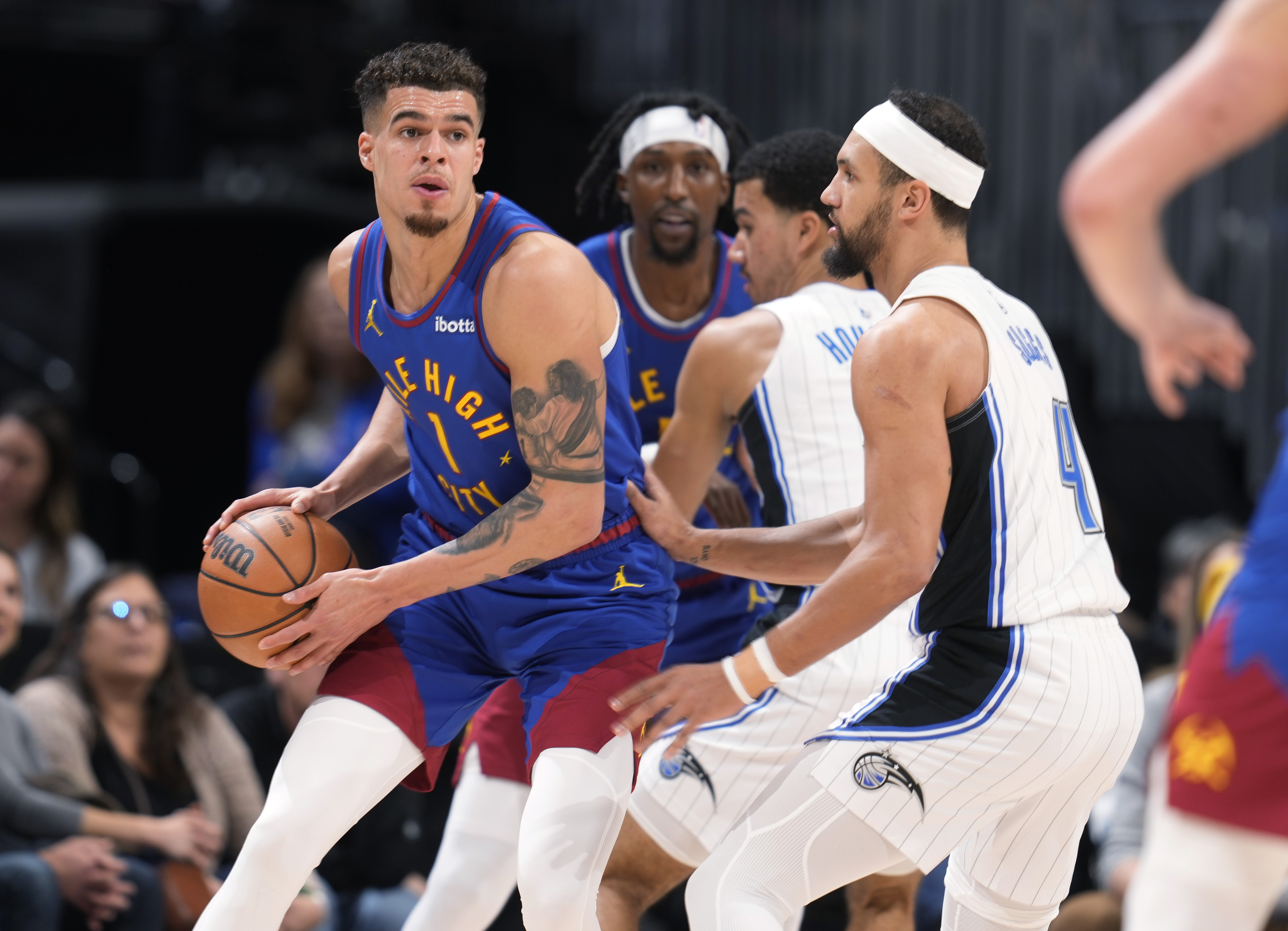 Denver Nuggets forward Michael Porter Jr., left, looks to pass the ball as Orlando Magic guard Jalen Suggs (4) defends in the first half of an NBA basketball game Friday, Jan. 5, 2024, in Denver. (AP Photo/David Zalubowski) (David Zalubowski)