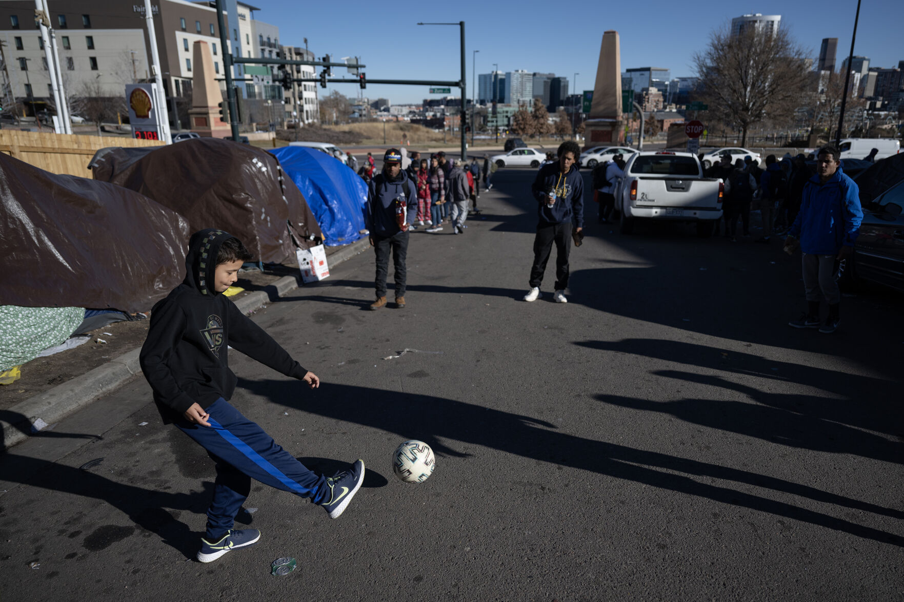 A group of young men and boys kick a soccer ball around at the migrant encampment at West 27th Avenue and Zuni Street on Friday, Dec. 29, 2023, in Denver, Colo. (Timothy Hurst/Denver Gazette) (TimHursttim.hurst@gazette.comhttps://secure.gravatar.com/avatar/aca82bd62b4ee425c598527cd6faa1b1?d=mm&r=g)