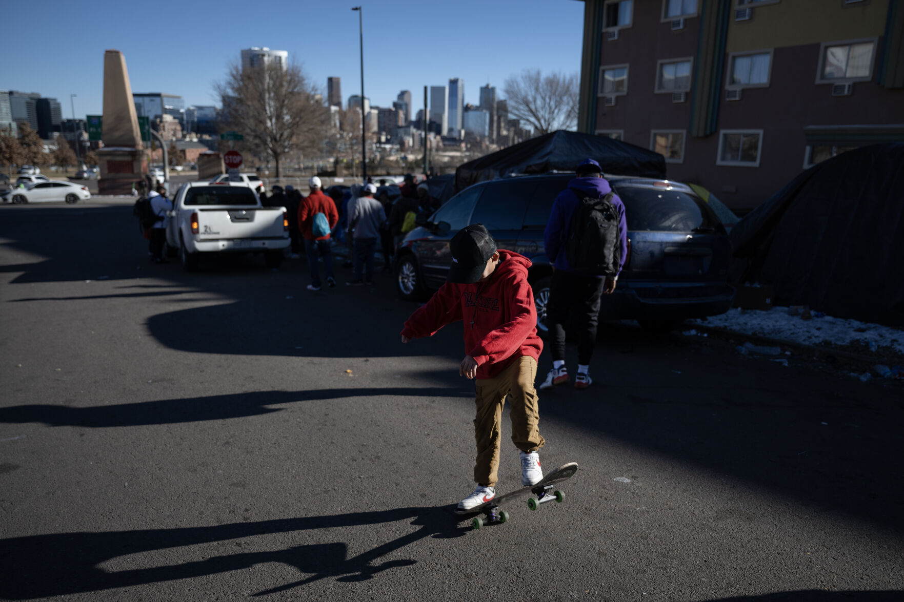 A boy rides a skateboard up and down West 27th Avenue at the migrant encampment near Zuni Street and North Speer Boulevard on Friday, Dec. 29, 2023, in Denver, Colo. (Timothy Hurst/Denver Gazette) (TimHursttim.hurst@gazette.comhttps://secure.gravatar.com/avatar/aca82bd62b4ee425c598527cd6faa1b1?d=mm&r=g)