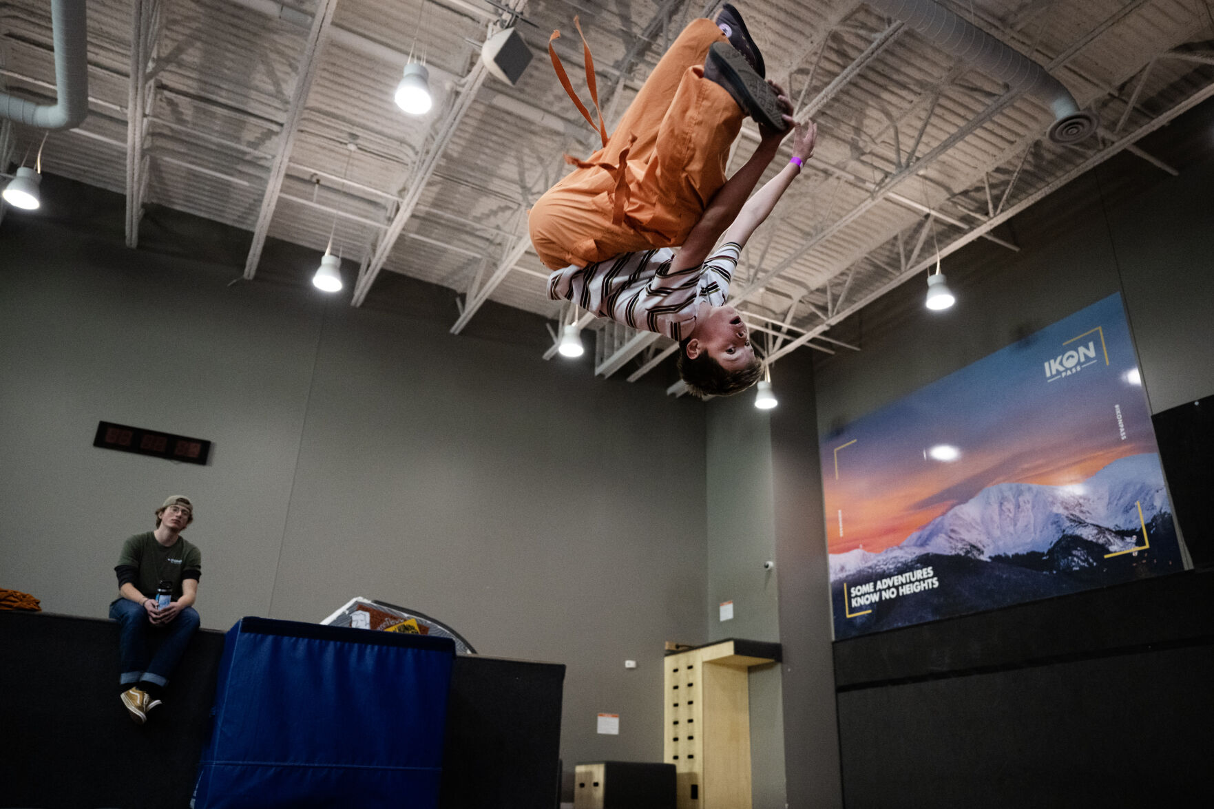 2023 USASA under 18 Slopestyle National Champion Cade Benton, 10, does a seemingly endless series of flips and twists on one of the large trampolines for dry land training while instructor Carter Wenger, left, keeps an eye on the trampoline area for safety on Wednesday, Jan. 24, 2024, at SNÖBAHN Indoor Ski + Snowboard Center in Centennial. (TimHursttim.hurst@gazette.comhttps://secure.gravatar.com/avatar/aca82bd62b4ee425c598527cd6faa1b1?d=mm&r=g)