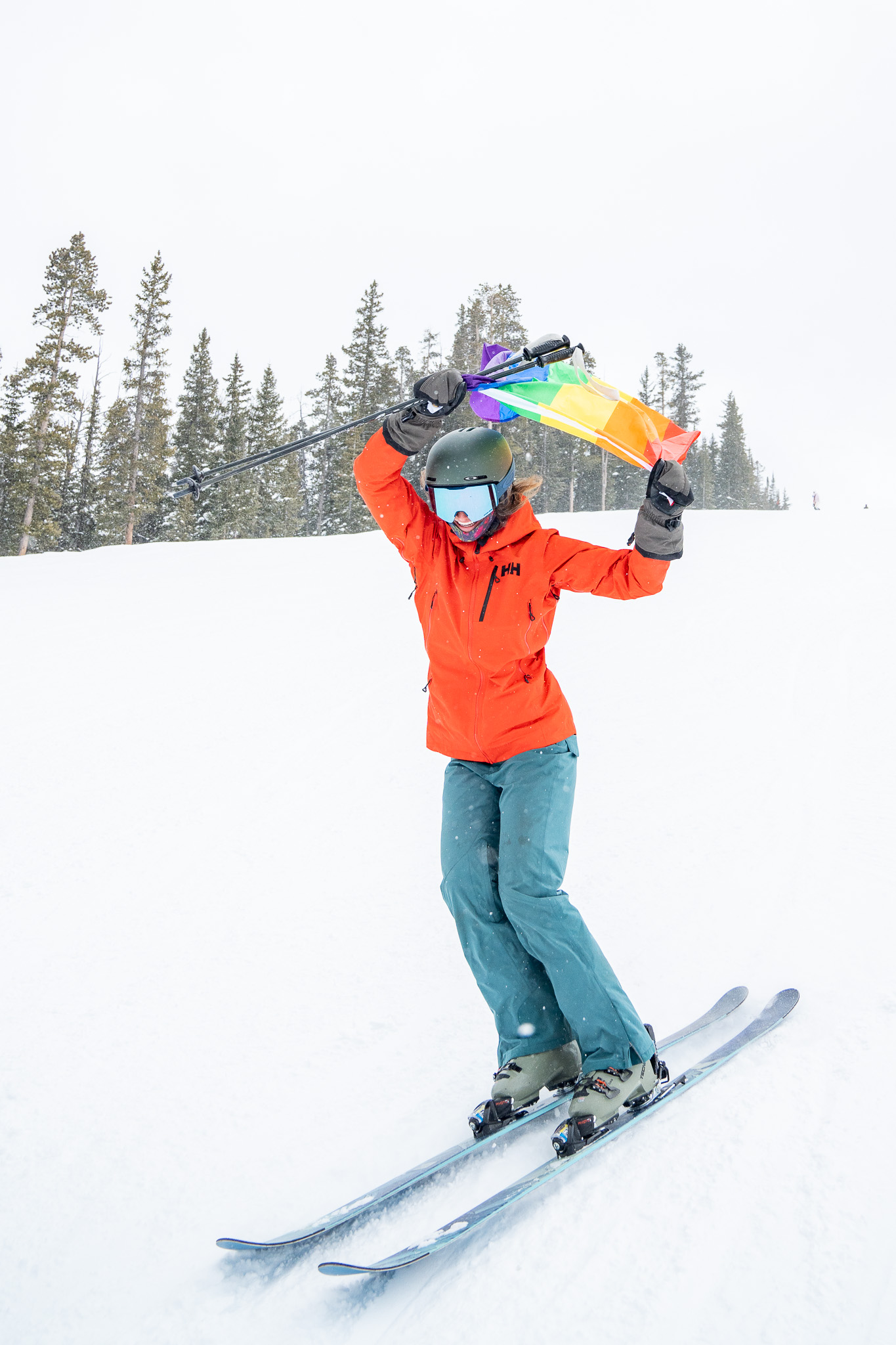 A skier holds a LGBTQ+ Pride flag on the slopes of Keystone Resort in Summit County. The resort is hosting its first Queer Ski Weekend March 1-2, 2024. (Katie Young, Keystone Mountain Resort)