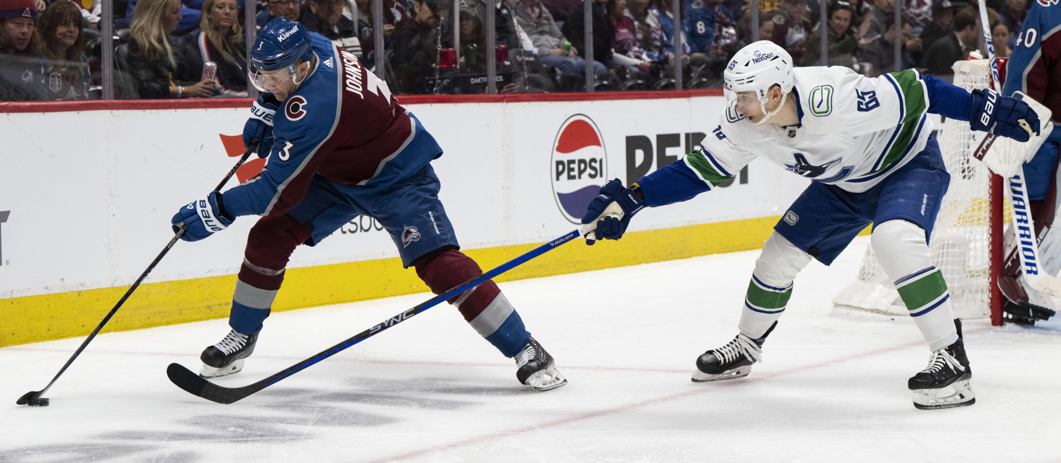 Colorado Avalanche defenseman Jack Johnson (3) keeps the puck away from Vancouver Canucks right wing Ilya Mikheyev (65) during the second period Tuesday, Feb. 20, 2024, at Ball Arena in Denver. (The Gazette, Christian Murdock) (Christian Murdock/The Gazette)