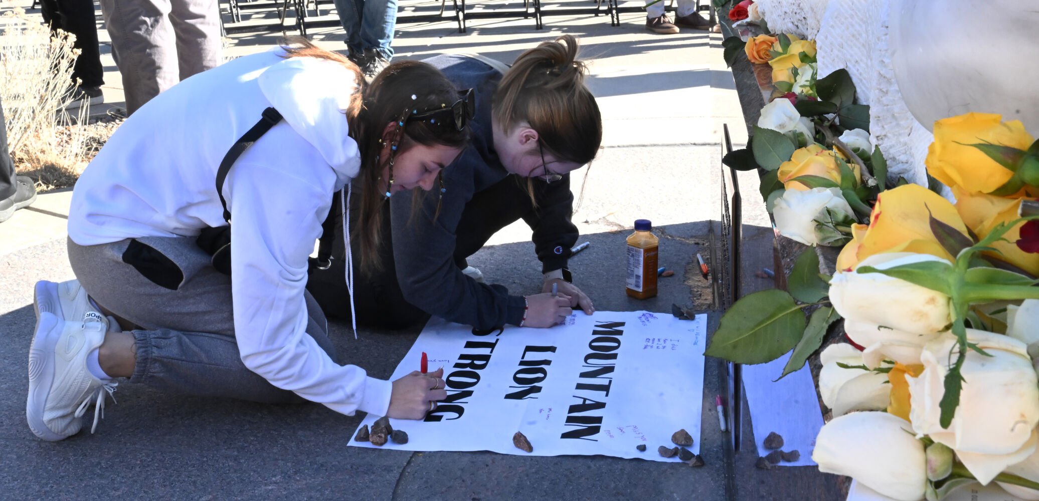 Willow Kitchens (front) signs a sign for her friend, Samuel Knopp, a student at the University of Colorado at Colorado Springs, after a Healing Walk at UCCS on Monday, Feb. 19, 2024. Knopp was one of the victims of a double homicide in a dorm last week. A suspect was arrested Monday. Also, a student suddenly died from a medical issue several days before the murders. (Photo by Jerilee Bennett, The Gazette)