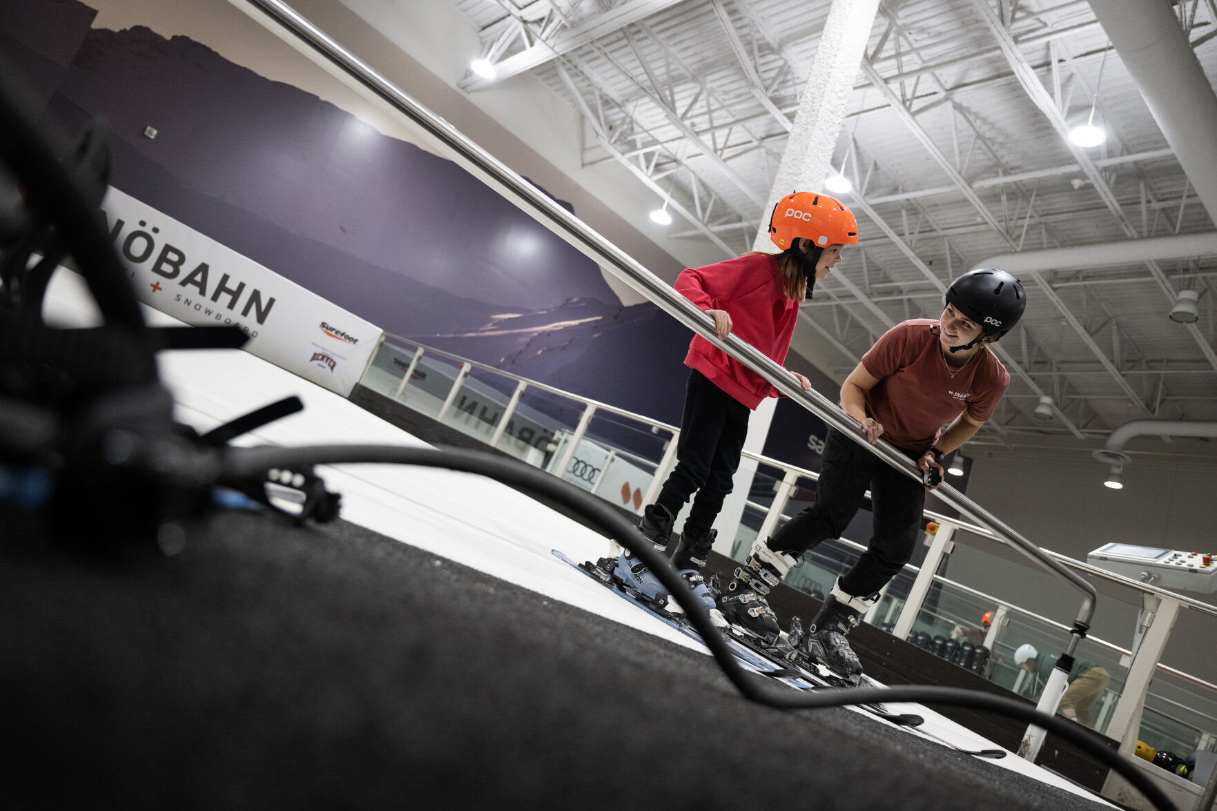 First-time skier Quinn Leensvaart, 7, looks to training manager and instructor Mary Davis as the artificial slope surface begins to slide under their skis during a lesson on one of the three indoor ski slopes on Wednesday, Jan. 24, 2024, at SNÖBAHN Indoor Ski + Snowboard Center in Centennial. (TimHursttim.hurst@gazette.comhttps://secure.gravatar.com/avatar/aca82bd62b4ee425c598527cd6faa1b1?d=mm&r=g)