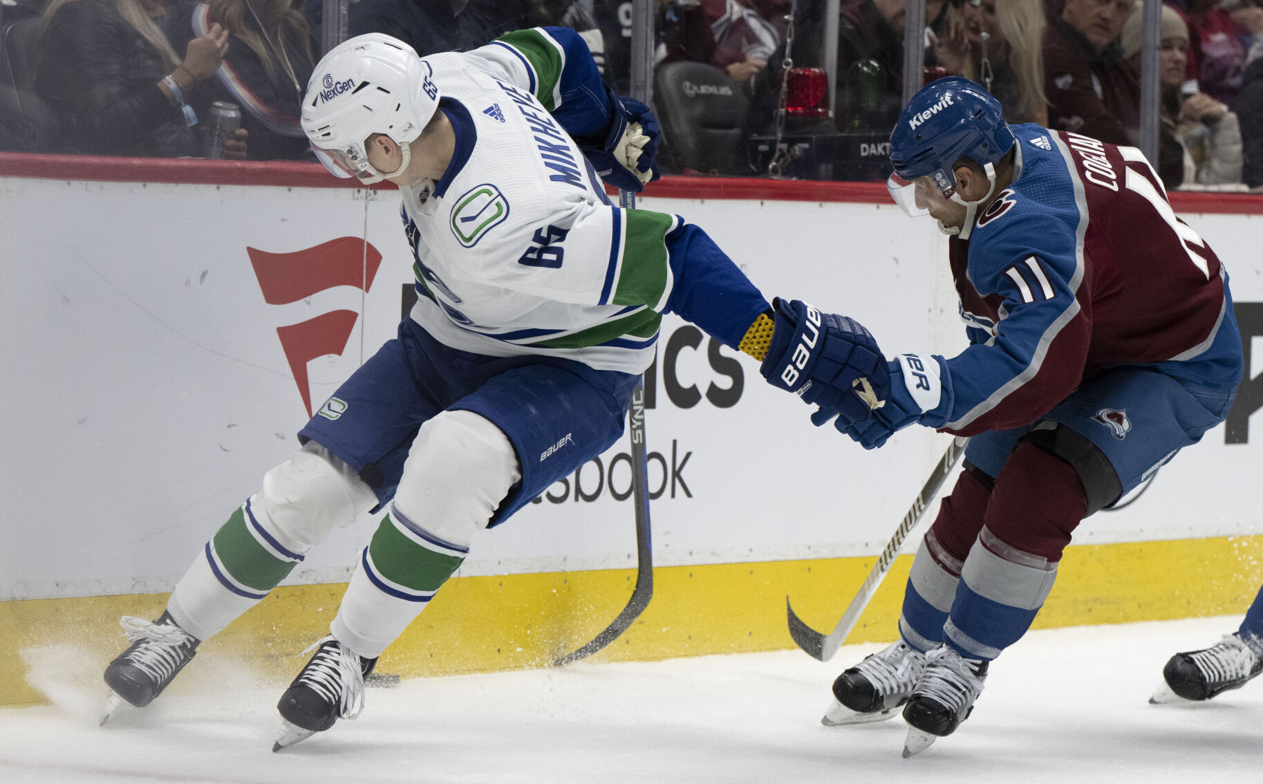 Vancouver Canucks right wing Ilya Mikheyev (65) battles Colorado Avalanche center Andrew Cogliano (11) for the puck in the corner during the second period Tuesday, Feb. 20, 2024, at Ball Arena in Denver. (The Gazette, Christian Murdock) (Christian Murdock/The Gazette)