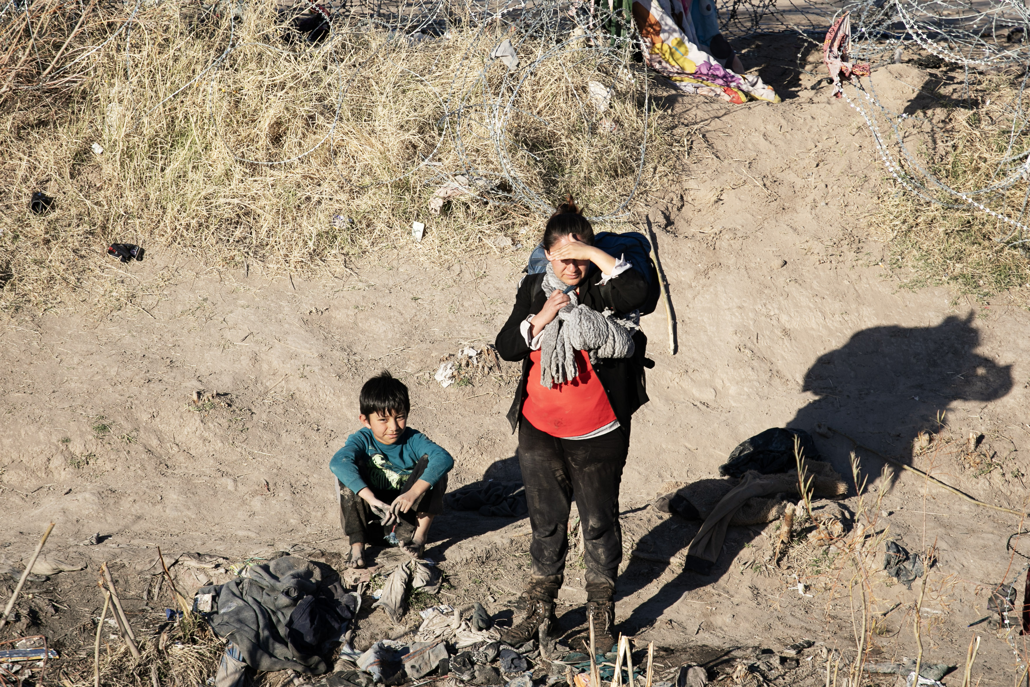 A woman and young child await more members of their traveling party on the northern bank of the Rio Grande between the United States and Mexico borders just south of El Paso, Texas on Thursday, Feb. 1, 2024. (Tom Hellauer, Denver Gazette) (TomHellauerMultimedia Producertom.hellauer@denvergazette.comhttps://denvergazette.com/content/tncms/avatars/f/9e/622/f9e6228a-3b6b-11ed-bf10-fbb71fa8e421.f54b911252c540f1d61709edc4727a39.png)