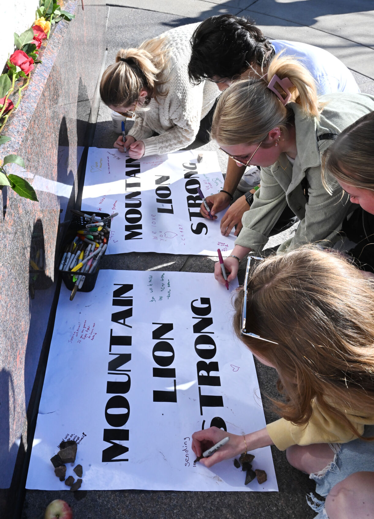 Student leave their sentiments on Mountain Lion Strong signs after a Healing Walk for the deaths that happened on campus last week. Two people were shot and killed in the dorms last Friday. A suspect was arrested Monday. Also, a student suddenly died from a medical issue several days before the murders. (Photo by Jerilee Bennett, The Gazette)