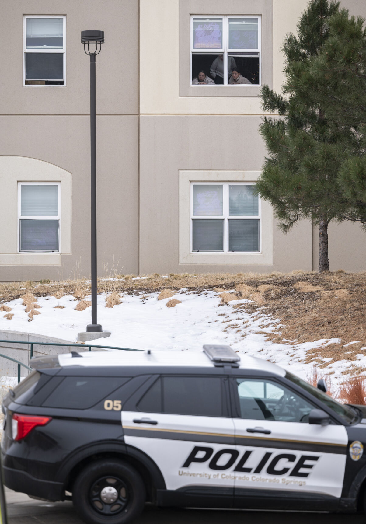 Students look outside their dorm window in the Village at Alpine Valley housing Friday, as police investigate a possible homicide on the University of Colorado Colorado Springs campus in Colorado Springs. (Christian Murdock, The Gazette)