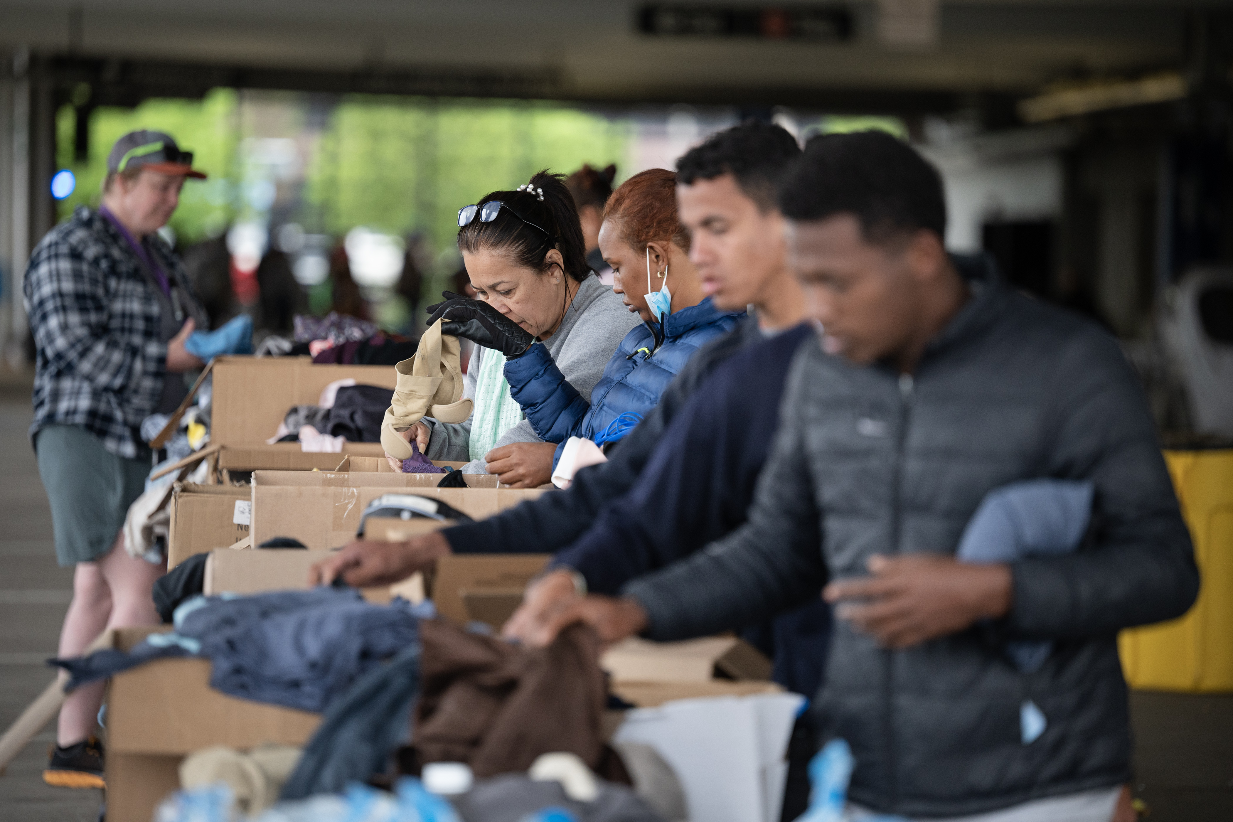 FILE PHOTO: Recently arrived immigrants pick through clothing while in a blocked-off parking garage on Wednesday, May 10, 2023, on the Auraria Campus in Denver. A new busload of immigrants, likely shipped from Texas, were dropped off at the State Capitol Monday. (TimHursttim.hurst@gazette.comhttps://secure.gravatar.com/avatar/aca82bd62b4ee425c598527cd6faa1b1?d=mm&r=g)