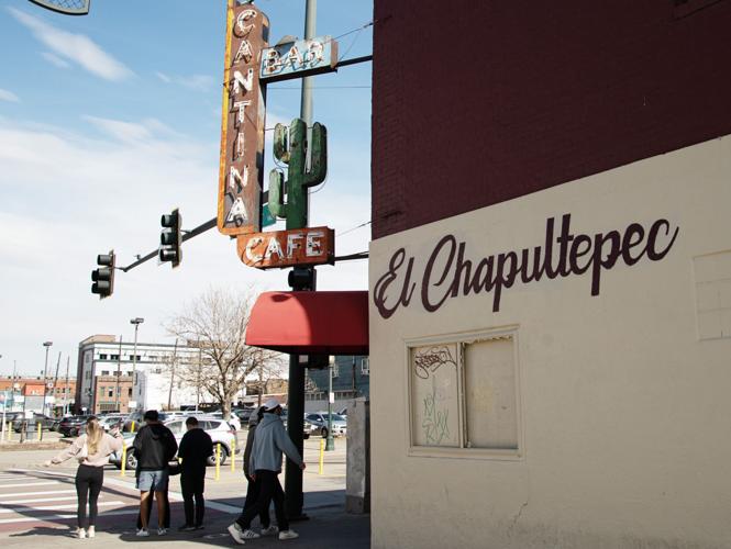 Passersby walk by the closed storefront of El Chapultepec