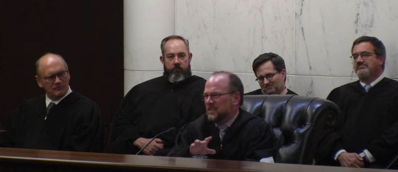 Judge Timothy J. Schutz speaks during his formal swearing-in ceremony to the Court of Appeals on Aug. 19, 2022. Behind him, from left to right, are Judges David Furman, W. Eric Kuhn, Craig R. Welling and Ted C. Tow III.