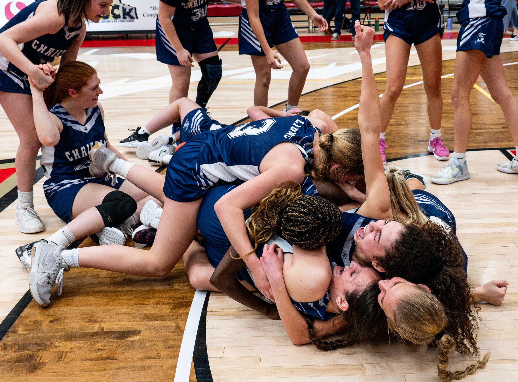 The Colorado Springs Christian School basketball team piles on the floor in celebration of a win over Peyton for their second consecutive 3A girls basketball state title on Saturday, March 9, 2024, at the University of Denver’s Hamilton Gym in Denver. (Parker Seibold, The Gazette) (Parker Seibold)
