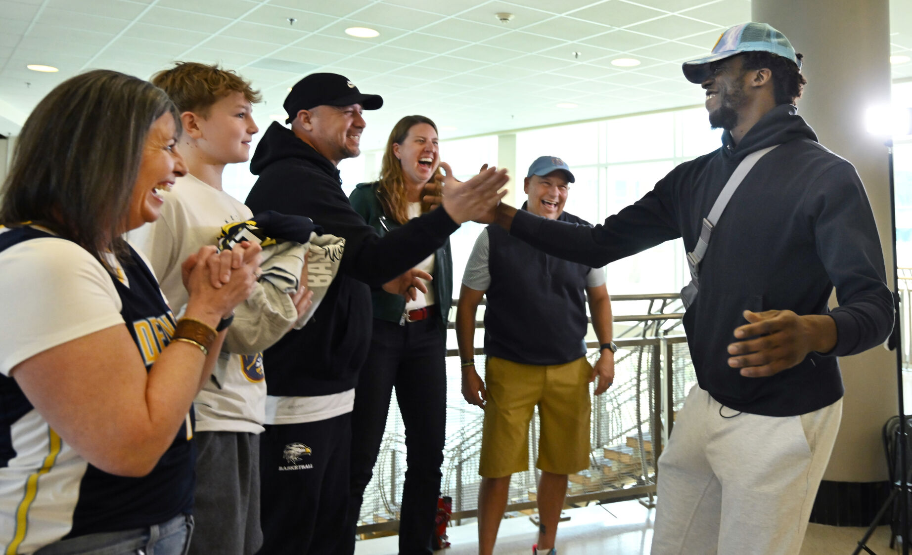 When Denver Nuggets’ Reggie Jackson, a Palmer High School graduate, came to Colorado Springs to visit patients at UCHealth Memorial Hospital North, he was surprised by a contingency from Palmer which included a couple of former teachers and coach. Reggie greets his former coach Jimmy Grantz, teacher Sara Osborne, current Palmer Coach Eric Trujillo, his son, Trevin Trujillo, and teacher Lindsey Keller (right to left) before going up to visit patients on Thursday, March 28, 2024. (Photo by Jerilee Bennett, The Gazette)