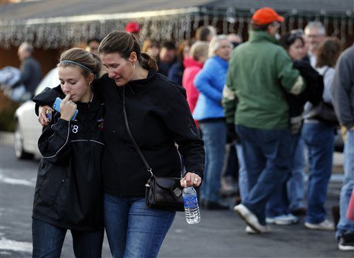 FILE PHOTO: A parent picks up her daughter at a church where students from nearby Arapahoe High School were evacuated to after a shooting on the Centennial, Colo., campus Friday, Dec. 13, 2013. Arapahoe County Sheriff Grayson Robinson said the shooter shot two others at the school, before apparently killing himself. (AP Photo/Brennan Linsley) (Brennan Linsley/Associated Press)