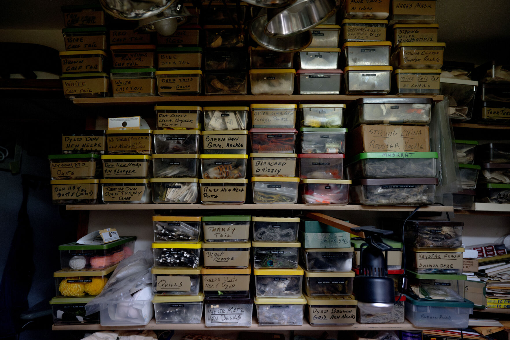 Boxes of supplies for salt water flies sits on the shelves at Best’s in-home workshop, on the other side the workshop sit more shelves of boxes full of everything you could need for fresh water ties. The boxes and materials within have gone untouched since last summer when he stopped tying flies following the death of his wife of 67 years. (Parker Seibold, The Gazette) (Parker Seibold)