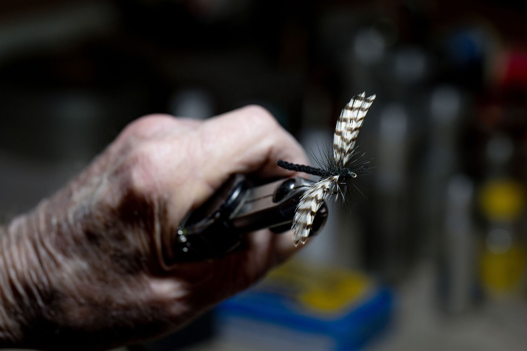 A.K. Best holds a dragonfly fishing fly in a tying vise. (Parker Seibold)