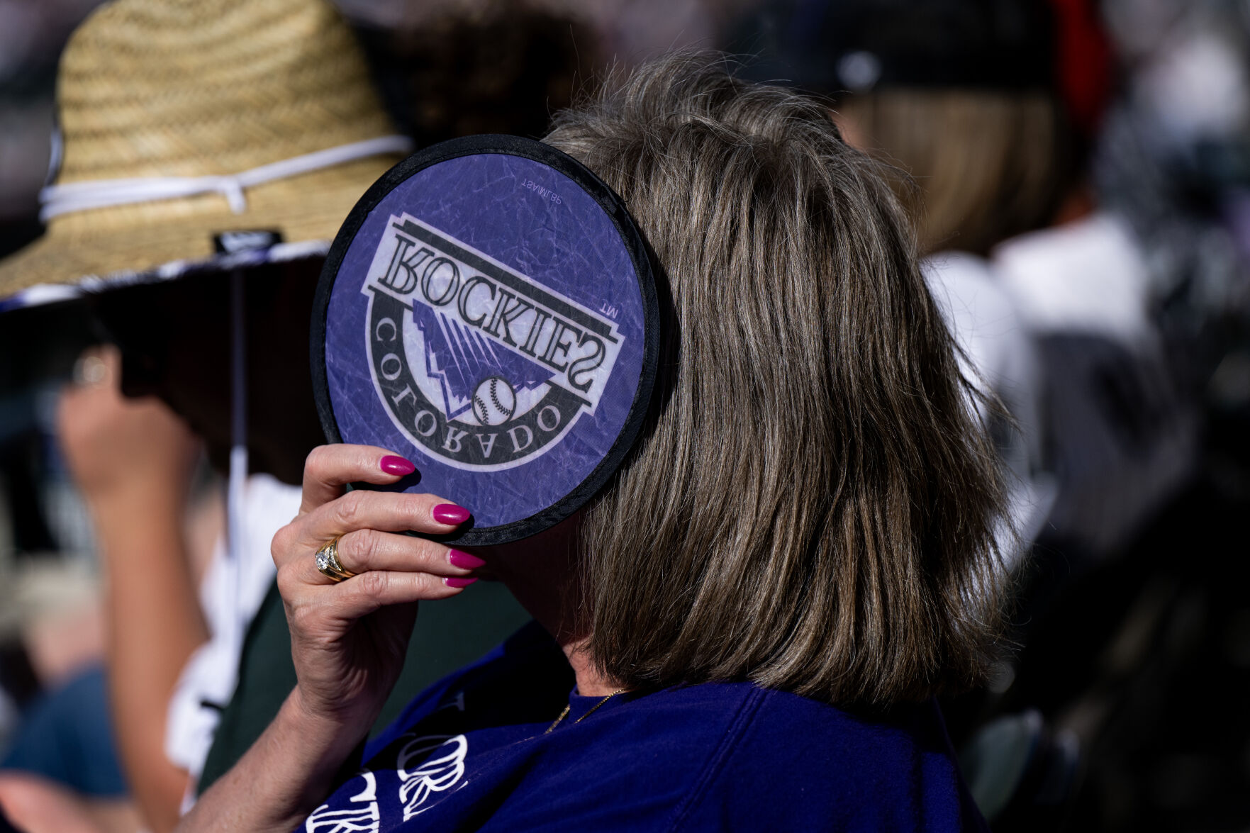 A Colorado Rockies fan holds a fan up for shade during a game at Coors Field, Friday, April 5, 2024, in Denver, Colo. (Parker Seibold, The Gazette) (Parker Seibold)