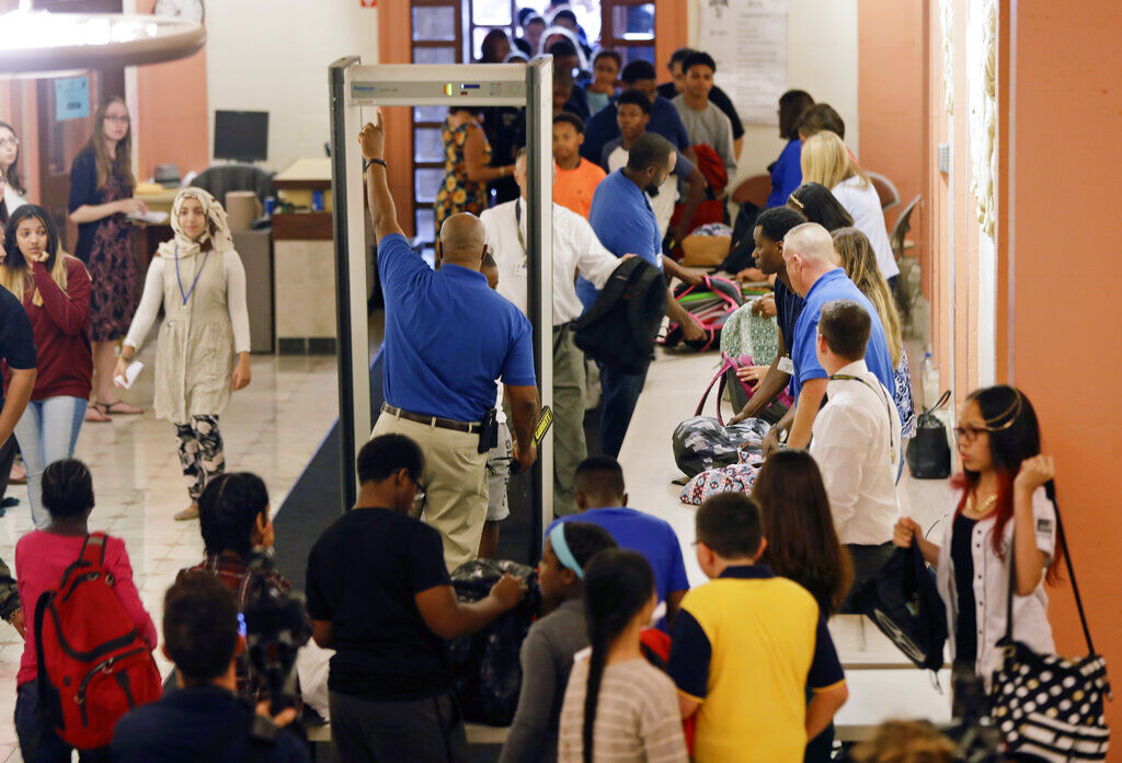 FILE PHOTO: In this Sept. 6, 2016, file photo, students at William Hackett Middle School have their bags checked and pass through metal detectors on the first day of school in Albany, N.Y. Twenty years after the Columbine High School shooting made practicing for armed intruders as routine as fire drills, many parents have only tepid confidence in the ability of schools to stop a gunman, according to a new poll by The Associated Press-NORC Center for Public Affairs Research. (AP Photo/Mike Groll, File) (Mike Groll/Associated Press)