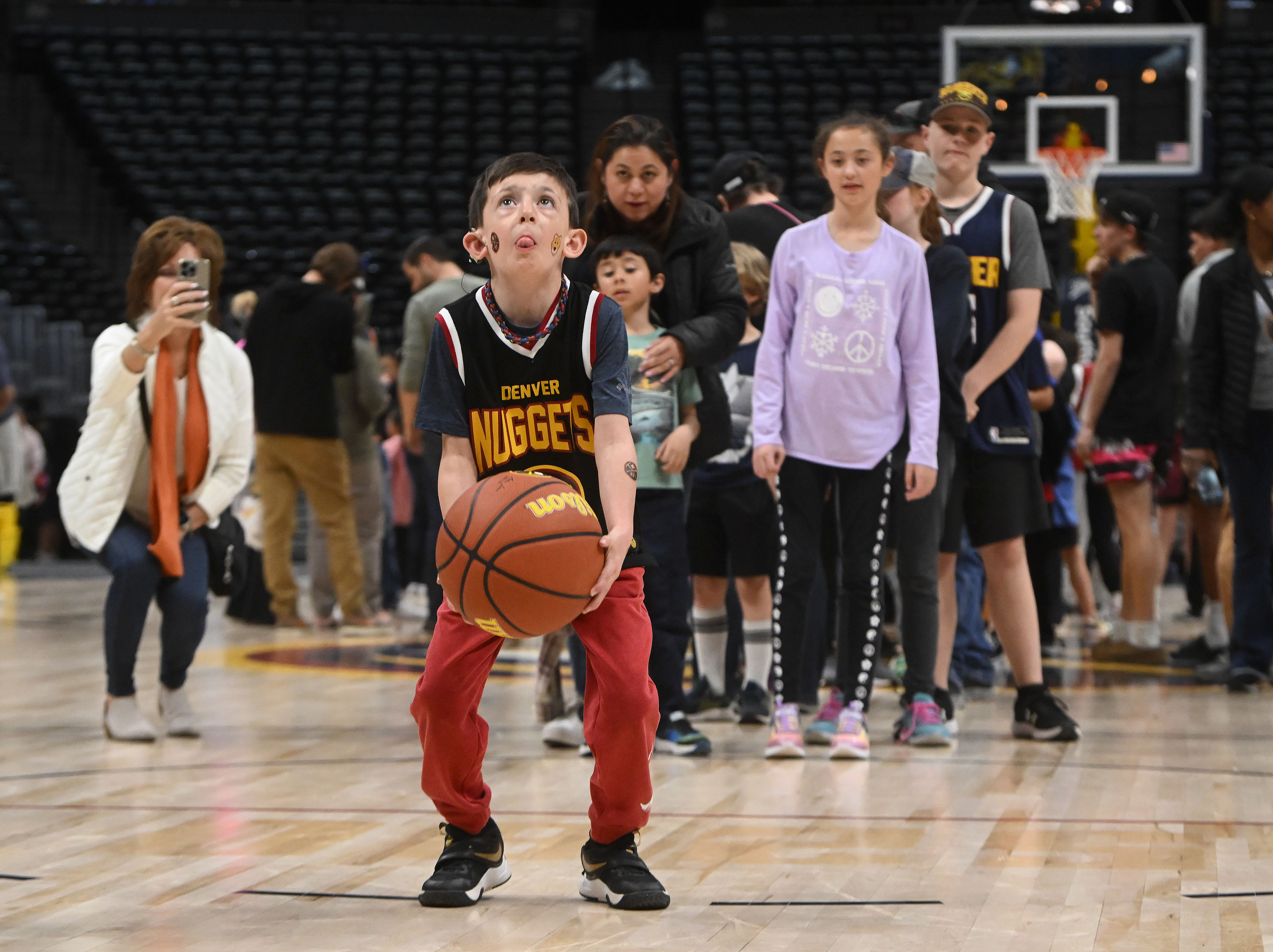 Macklin Carlson and other Nuggets attendees get one shot at a free throw in an event after a Nuggets game. An hour long intramural game between CSU and CU pushes pack the conversion start to near midnight. Afterward, Ball Arena was transformed from Nuggets to Avalanche overnight on Thursday, March 21, 2024. (Photo by Jerilee Bennett, The Gazette)