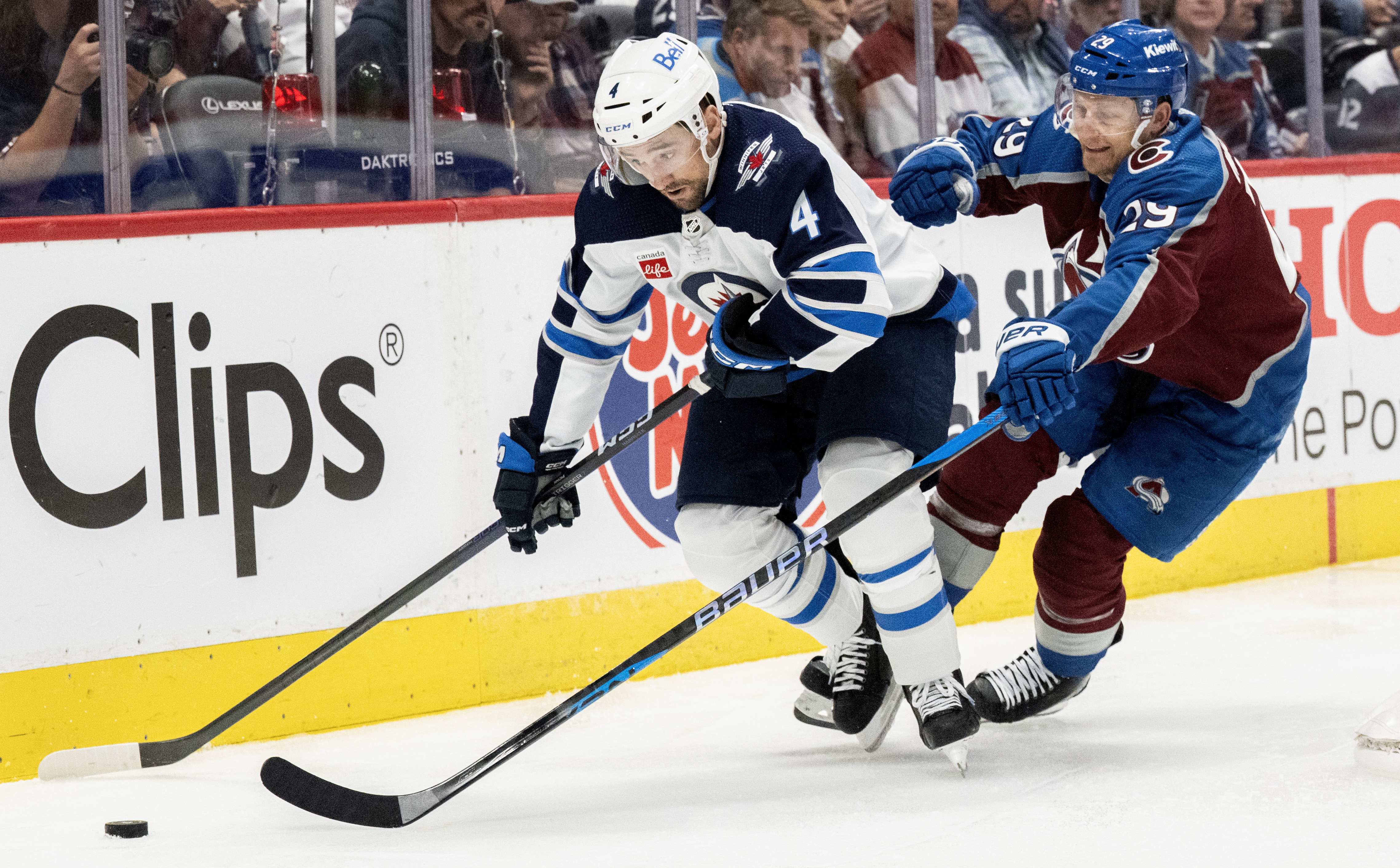 Winnipeg Jets defenseman Neal Pionk (4) moves the puck behind the Winnipeg Jets goal as Colorado Avalanche center Nathan MacKinnon (29) defends during the third period in Game 4 of an NHL Stanley Cup first-round playoff series Sunday, April 28, 2024, at Ball Arena in Denver. The Avalanche won 5-1 to take a 3-1 advantage in the series. (The Gazette, Christian Murdock) (Christian Murdock/The Gazette)