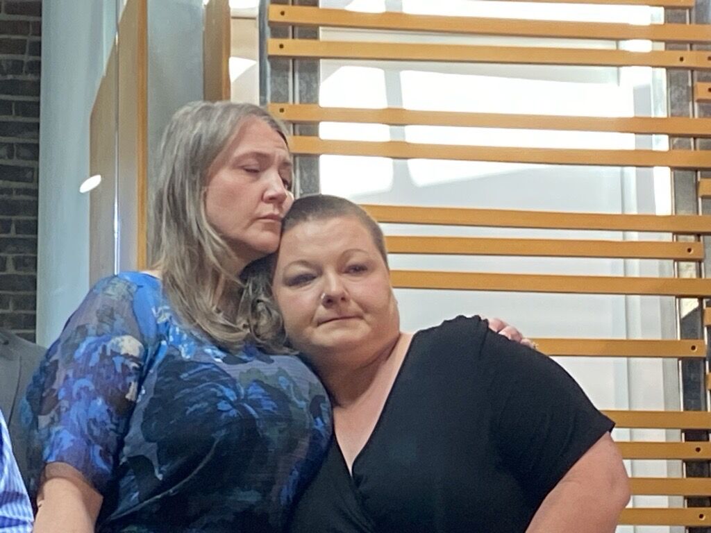 Brittany Yarborough, right, is hugged by a mom who identified herself only as Jessica Tuesday at a press conference. Yarborough's son was allegedly assaulted by a paraprofessional on a Littleton Public Schools bus for special needs children. (Carol McKinley/Denver Gazette)