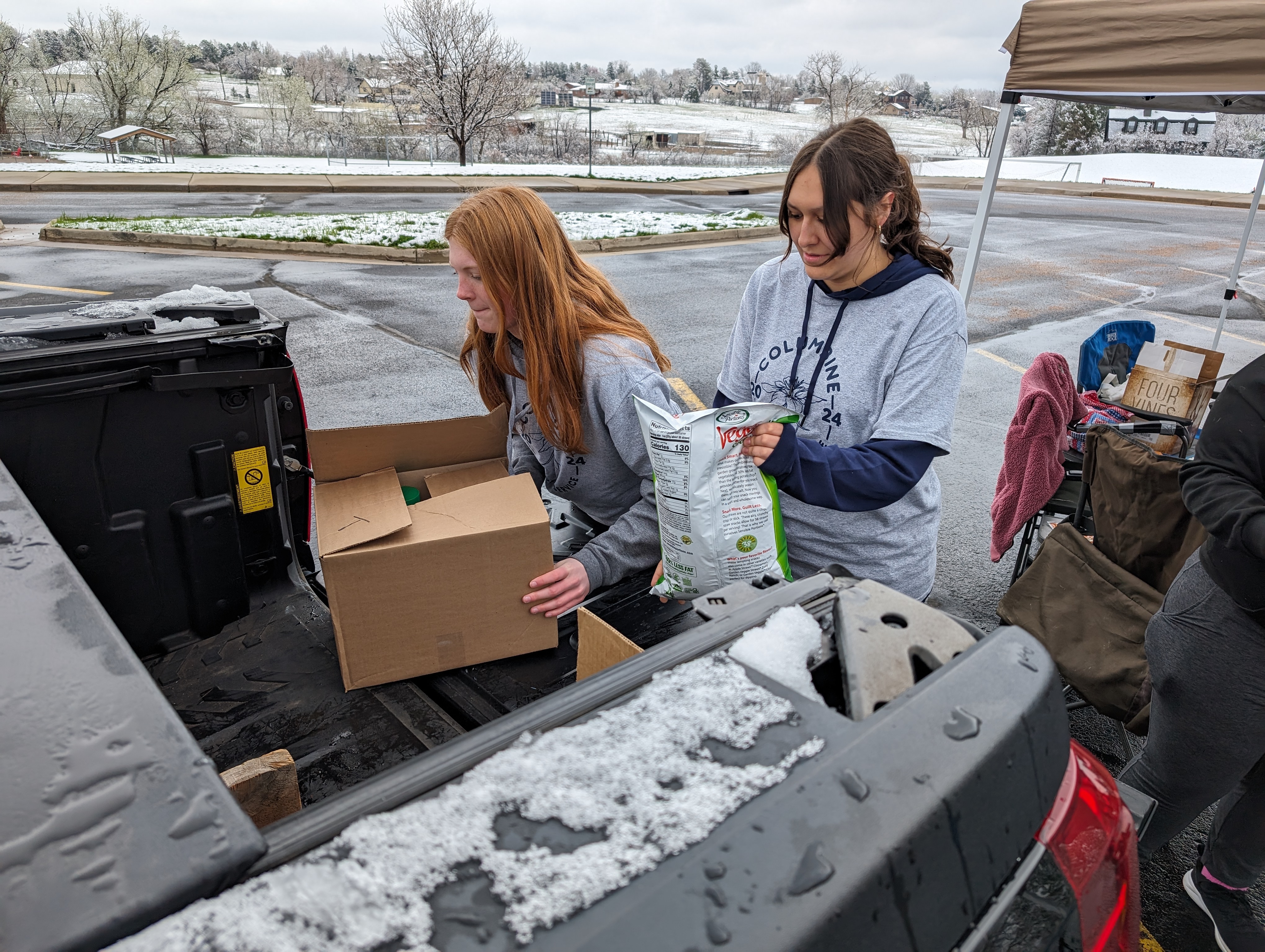 Heidi Heivilin, left, and Maia Kurtz, students of Columbine High School, collect donated food for a food drive during the Columbine Day of Service on Saturday.
