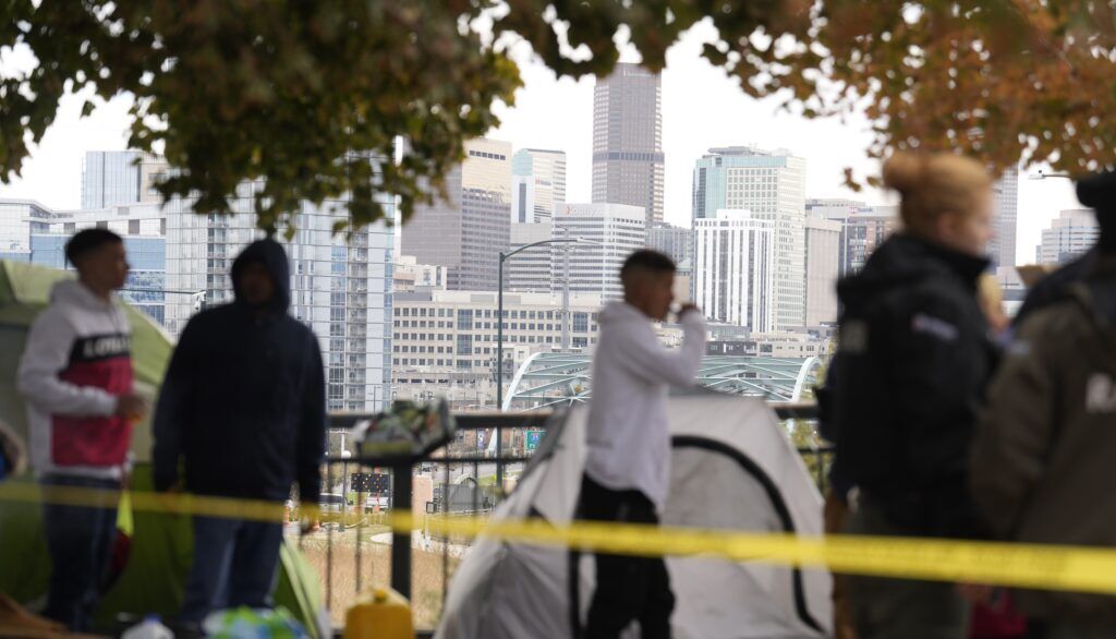 Occupants wait to see how police officers work during a city-sponsored sweep of an encampment overlooking the city skyline on Diamond Hill Wednesday, Nov. 1, 2023, in Denver. The sweep was just one of several staged in various locations across the Mile High City. (AP Photo/David Zalubowski) (David Zalubowski)