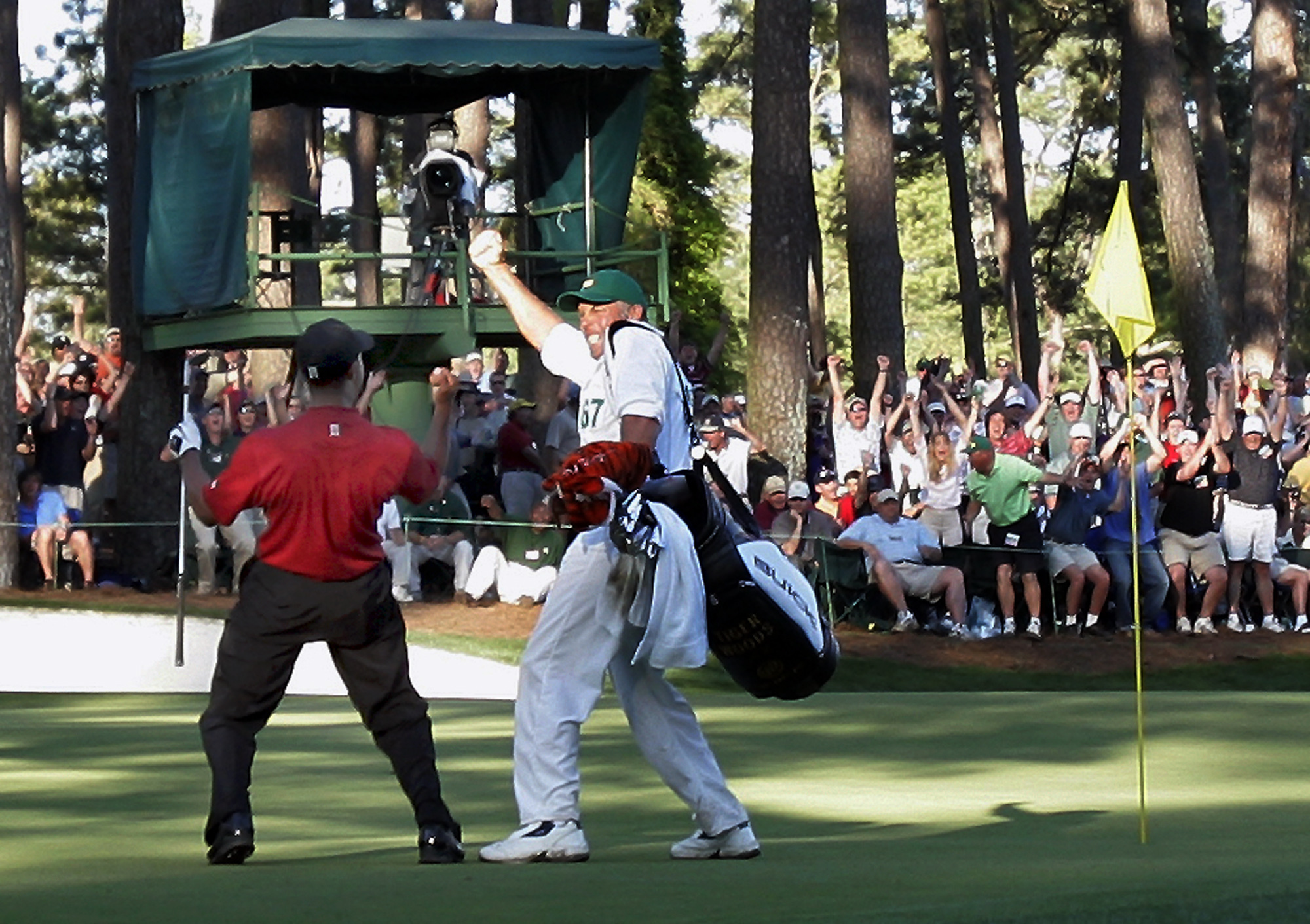 FILE - In this April 10, 2005, file photo, Tiger Woods celebrates with his caddie Steve Williams after his chip-in birdie on the 16th hole during the Masters golf tournament at Augusta National Golf Club in Augusta, Ga. The chip-in is among his most famous moments at the Masters. (AP Photo/Elise Amendola, File) (ELISE AMENDOLA)