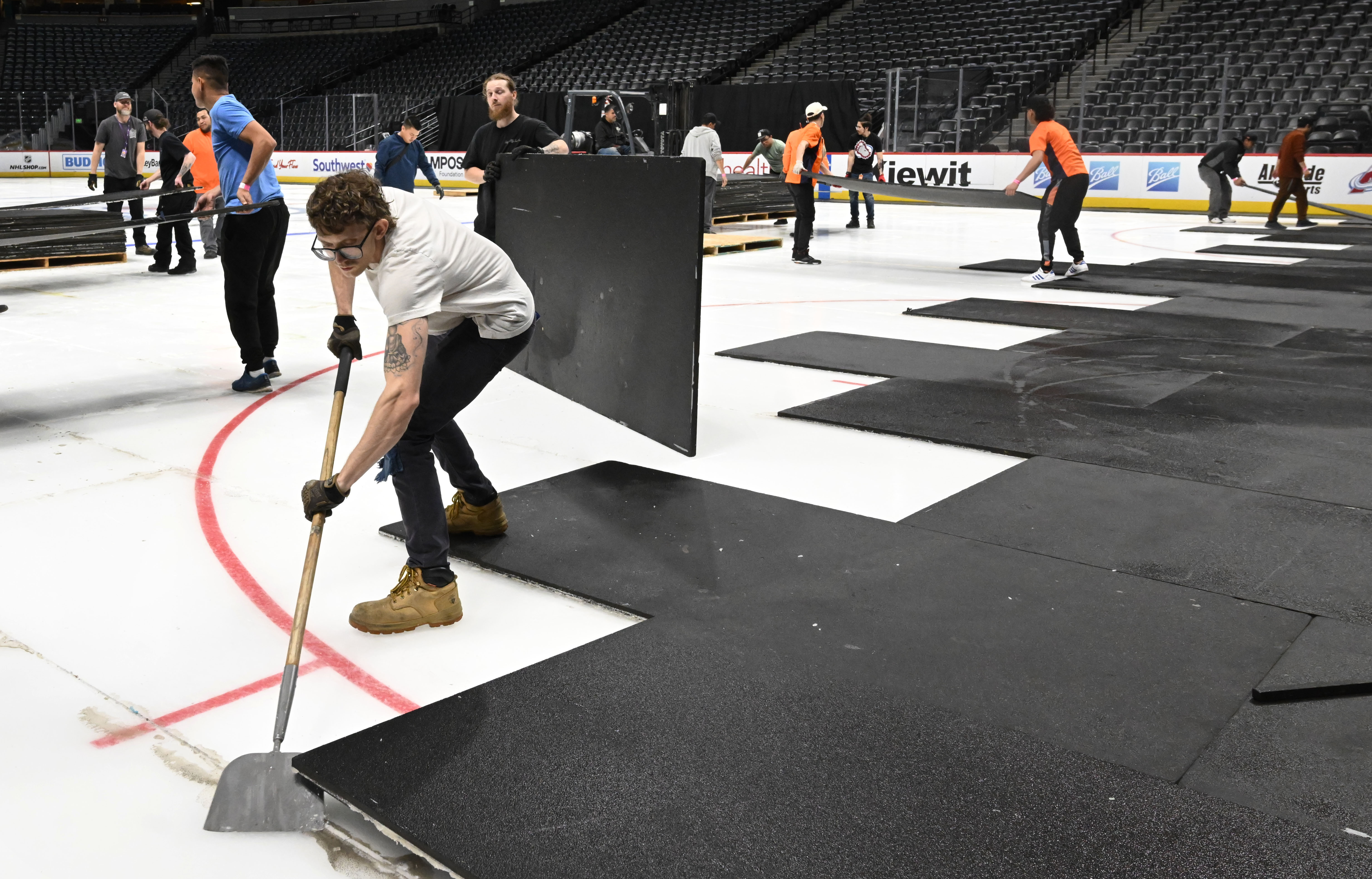 After removing the Nuggets wooden floor, crews remove tiles to reveal the Avalanche ice underneath. Crews were converting Ball Arena from Nuggets to Avalanche overnight on Thursday, March 21, 2024. (Photo by Jerilee Bennett, The Gazette)