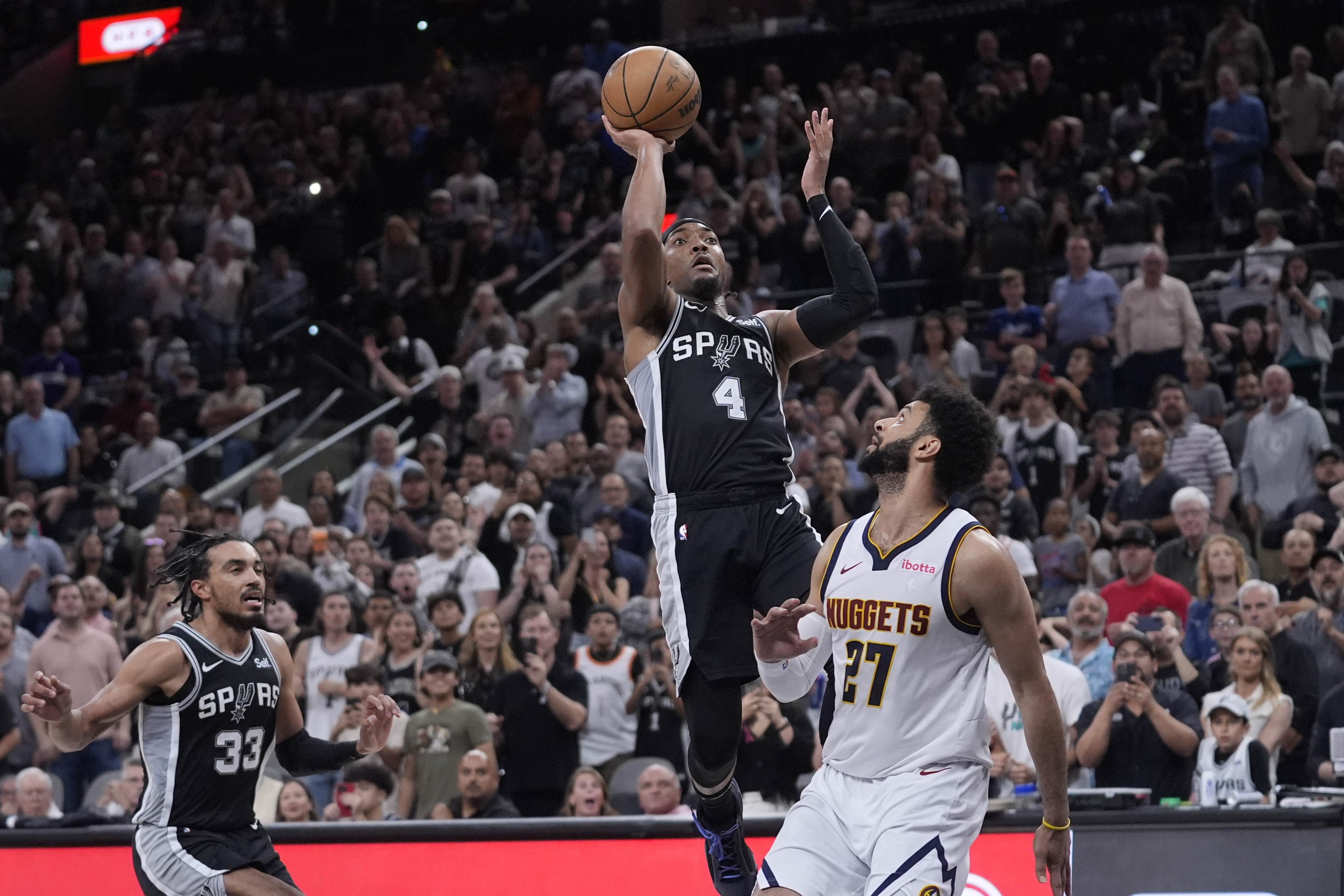 San Antonio Spurs guard Devonte' Graham (4) scores the winning shot over Denver Nuggets guard Jamal Murray (27) during the second half of an NBA basketball game in San Antonio, Friday, April 12, 2024. (AP Photo/Eric Gay) (Eric Gay)