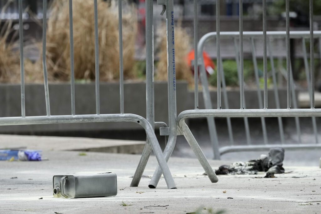 A metal can sits on the ground at the scene where a man lit himself on fire in a park outside Manhattan criminal court, Friday, April 19, 2024, in New York. Emergency crews rushed away a person on a stretcher after fire was extinguished outside the Manhattan courthouse where jury selection was taking place Friday in Donald Trump's hush money criminal case. (AP Photo/Mary Altaffer) (Mary Altaffer)