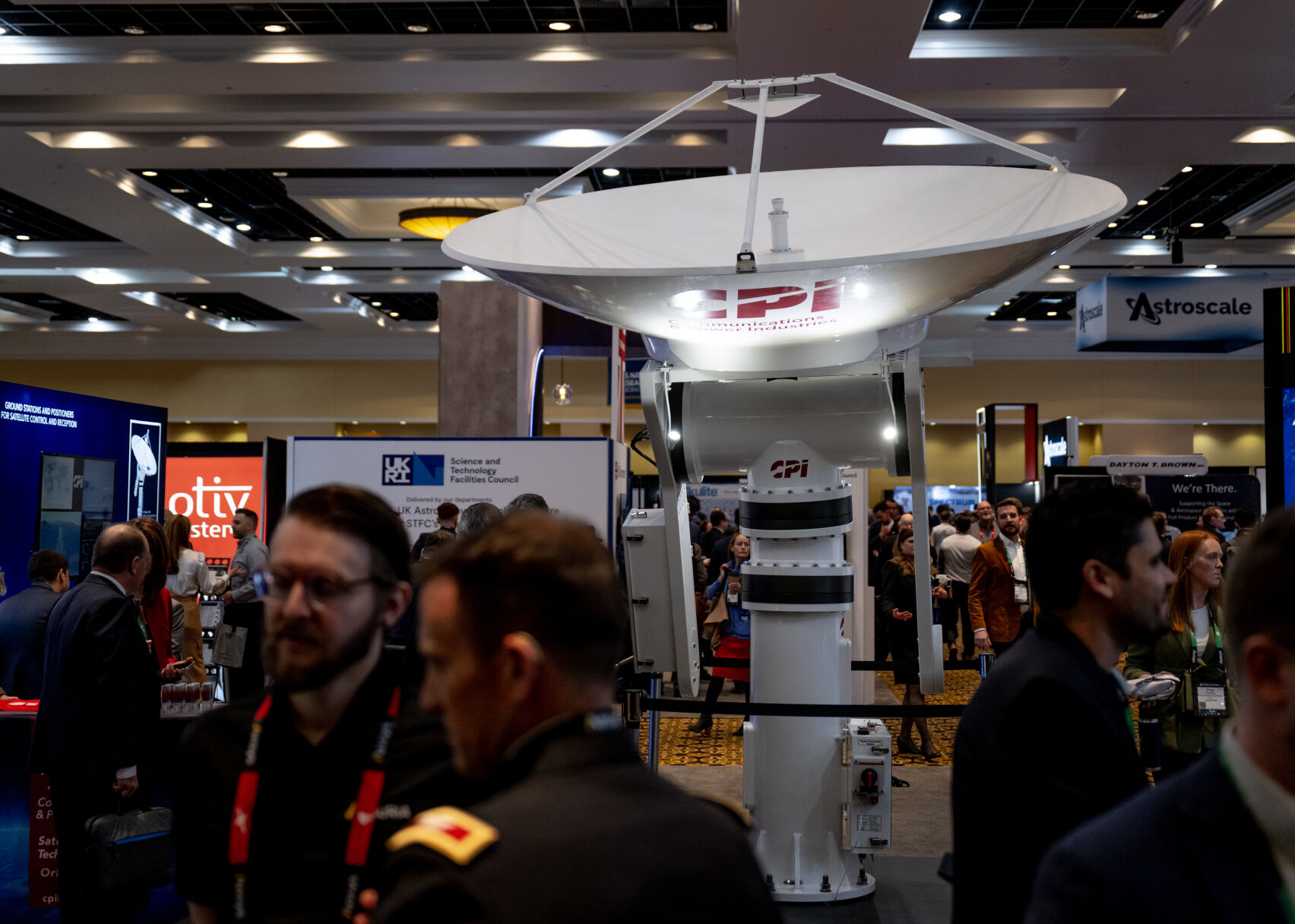 A satellite in the Communication and Power Industries exhibition towers over Space Symposium attendees, Tuesday, April 9, 2024, at The Broadmoor Hotel in Colorado Springs, Colo. (Parker Seibold, The Gazette) (Parker Seibold)