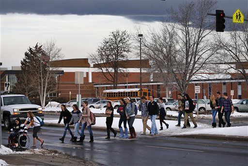 FILE PHOTO: Arapahoe High School students cross the street in front of their school on the first day of classes since a fatal Dec. 13 shooting on campus, in Centennial, Colo., Tuesday Jan. 7, 2014. Students have not attended classes since Karl Pierson, a senior at Arapahoe, entered the school with a shotgun - reportedly with a possible grudge against a teacher - and fatally shot student Claire Davis before killing himself. (AP Photo/Brennan Linsley) (Brennan Linsley/Associated Press)