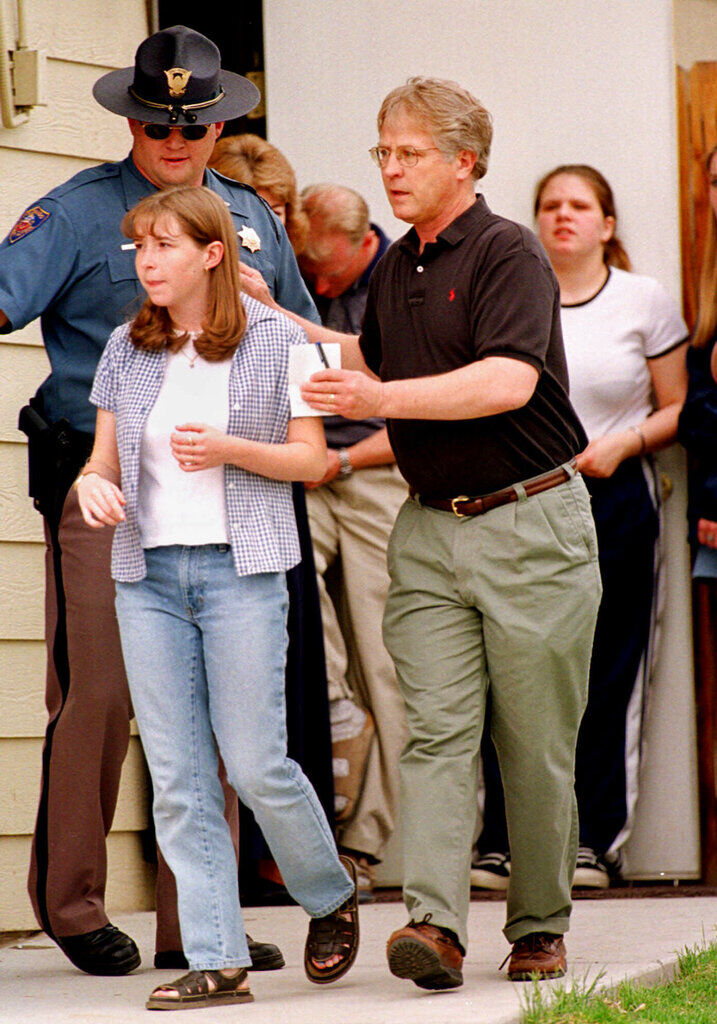 FILE PHOTO: A student from Columbine High School in Littleton, Colo., left, is led away from a home near the school by a relative after the young woman and more than two dozen other students were evacuated from the school on Tuesday, April 20, 1999. Two young men opened fire inside the school and 12 people and a teacher were killed. Two suspects were found dead inside the library hours later, he said. (AP Photo/David Zalubowski) (David Zalubowski/Associated Press)