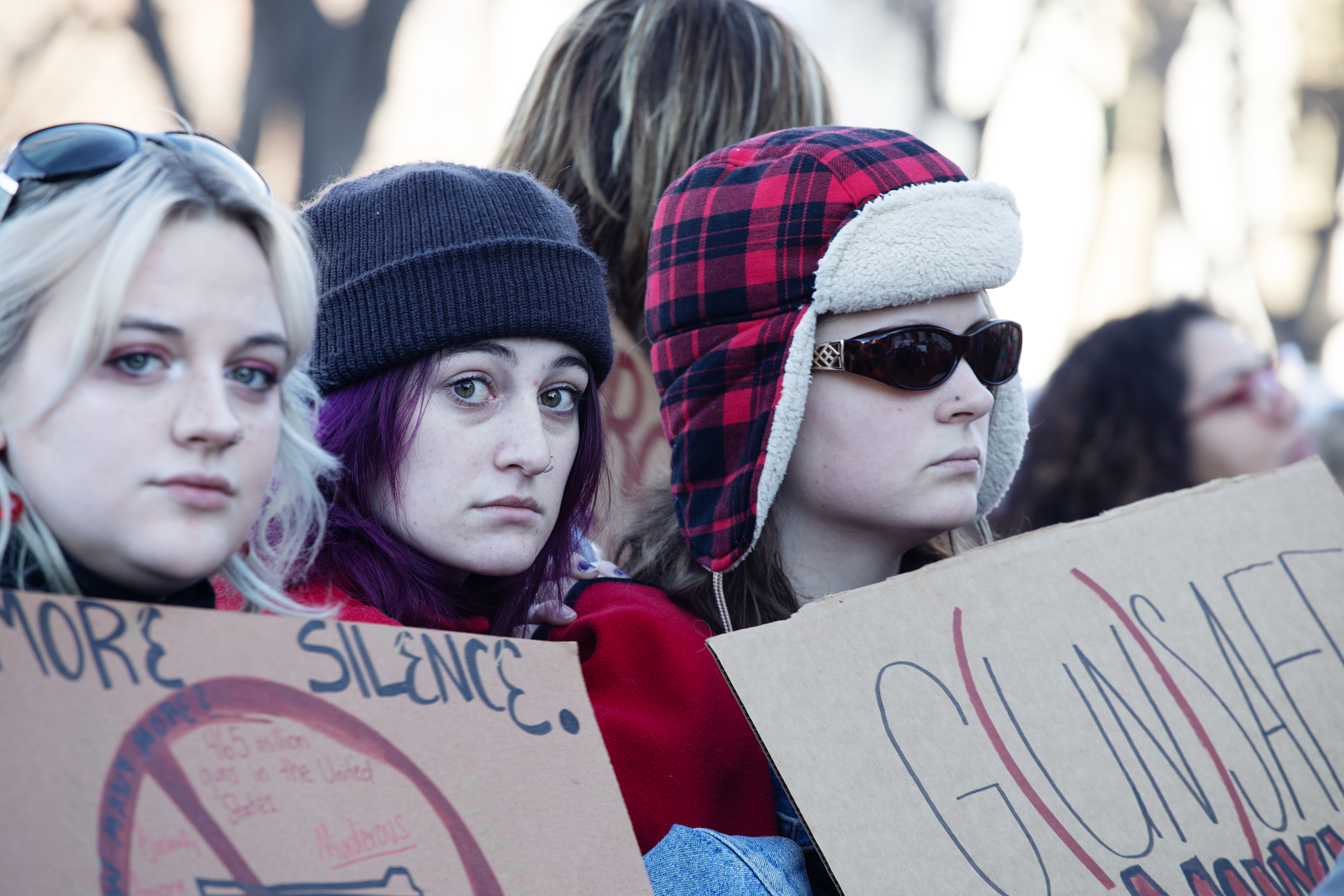 FILE PHOTO: From left, Jada Rouse, Sofie Davidson and Drew Moore, hold signs as they listen to speakers outside of the Colorado Capitol on Friday. For a second straight day, hundreds of Denver East High students descended on the Capitol in an effort to persuade lawmakers to take action on gun reform bills following another student-involved shooting. (Tom Hellauer/Denver Gazette)