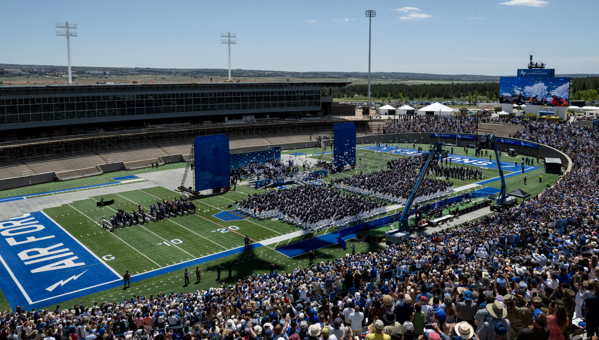 The United States Air Force Thunderbirds cast shadows over Falcon Stadium as graduates throw their caps during the Air Force Academy graduation at Falcon Stadium on Thursday, May 30, 2024, in Colorado Springs, Colo. (Parker Seibold, The Gazette) (Parker Seibold)