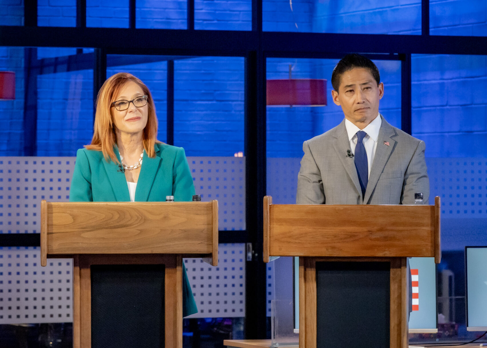 Candidate Deborah Flora and Peter Yu listen to questions posed by debate moderators on May 30. (Tom Green, 9News)