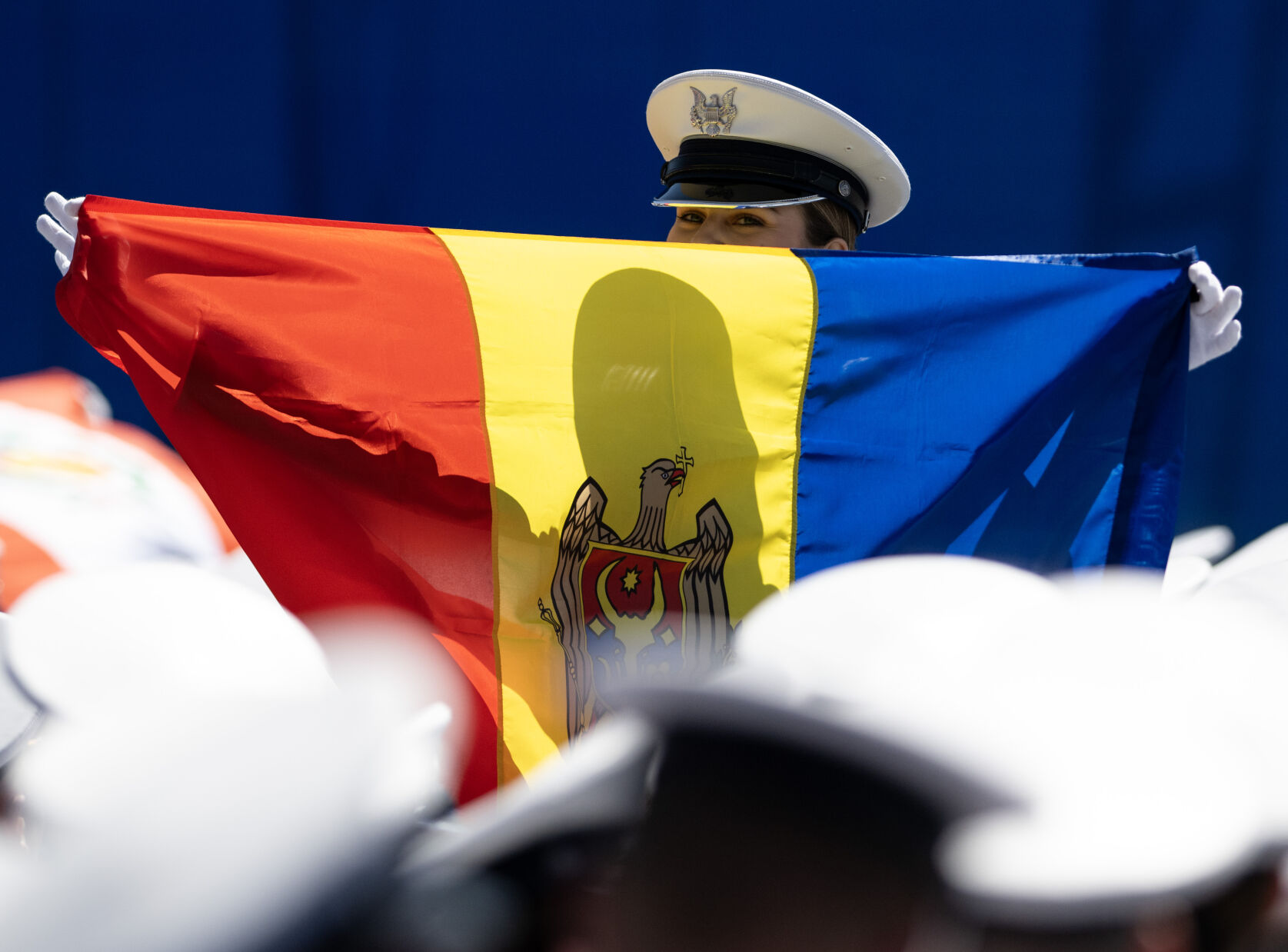 A graduate holds up a Romanian flag at the United States Air Force Academy graduation at Falcon Stadium on Thursday, May 30, 2024, in Colorado Springs, Colo. (Parker Seibold, The Gazette) (Parker Seibold)