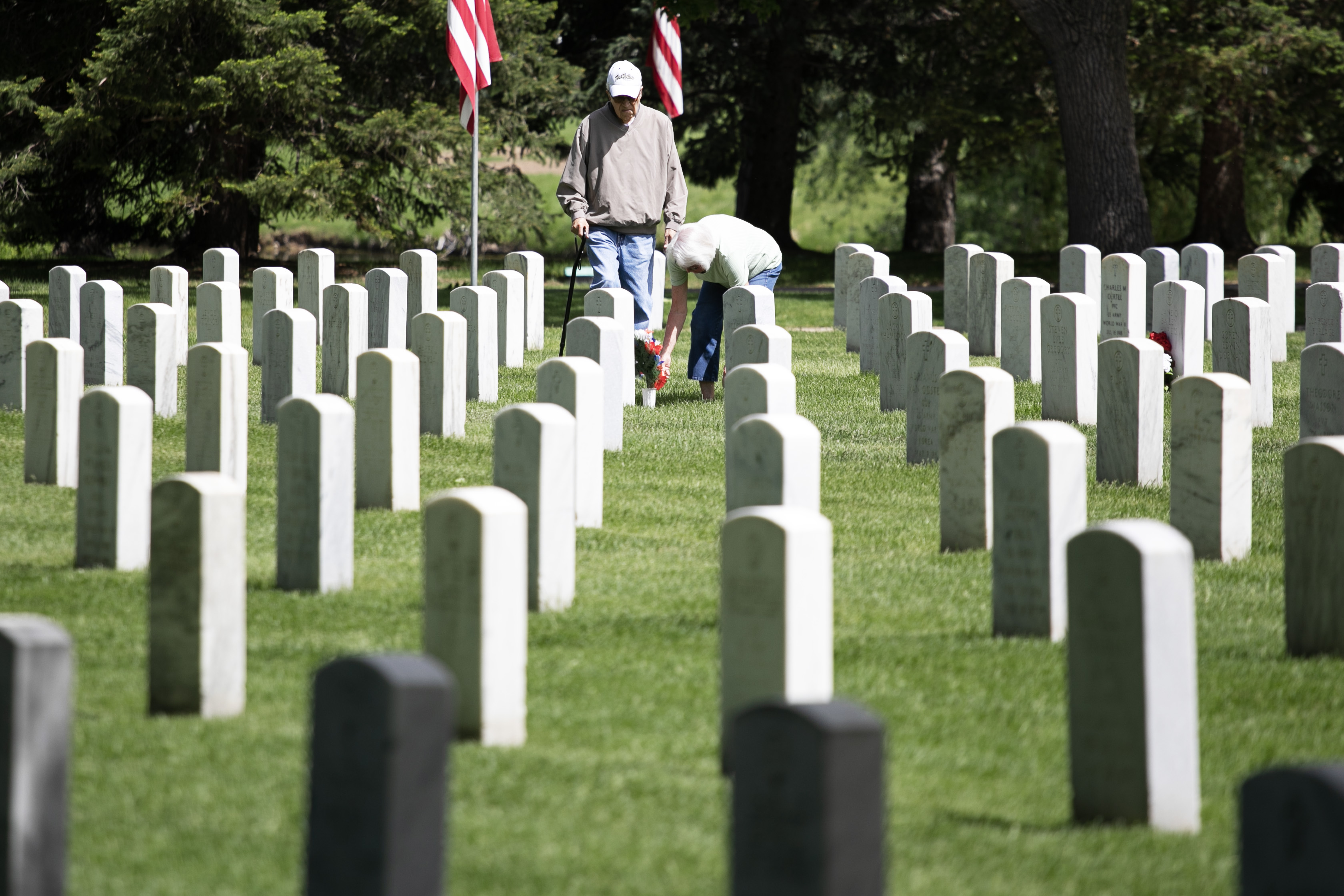 George Vialpando, left, and his wife Maryella Vialpondo pay their respect to Maryella's late aunt and uncle at Fort Logan National Cemetery on Friday, May 24, 2024. George served in Army and Maryella's mother and father are also at the cemetery.