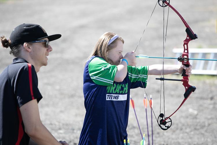 Kevin Bierbaum, left, watches Sara Riley practice archery