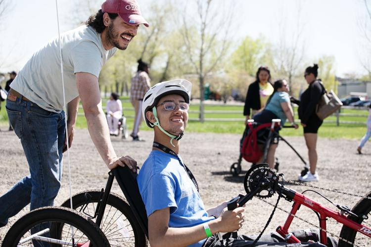 Emilio Suarez, left, helps push Buddy Reynolds in an adaptive bicycle